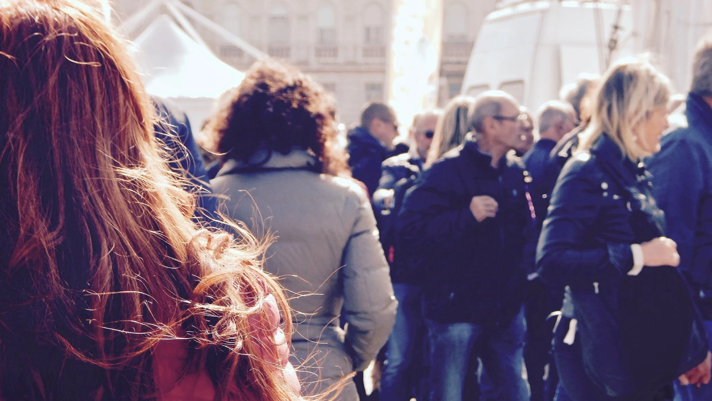 Woman stands till in crowded street