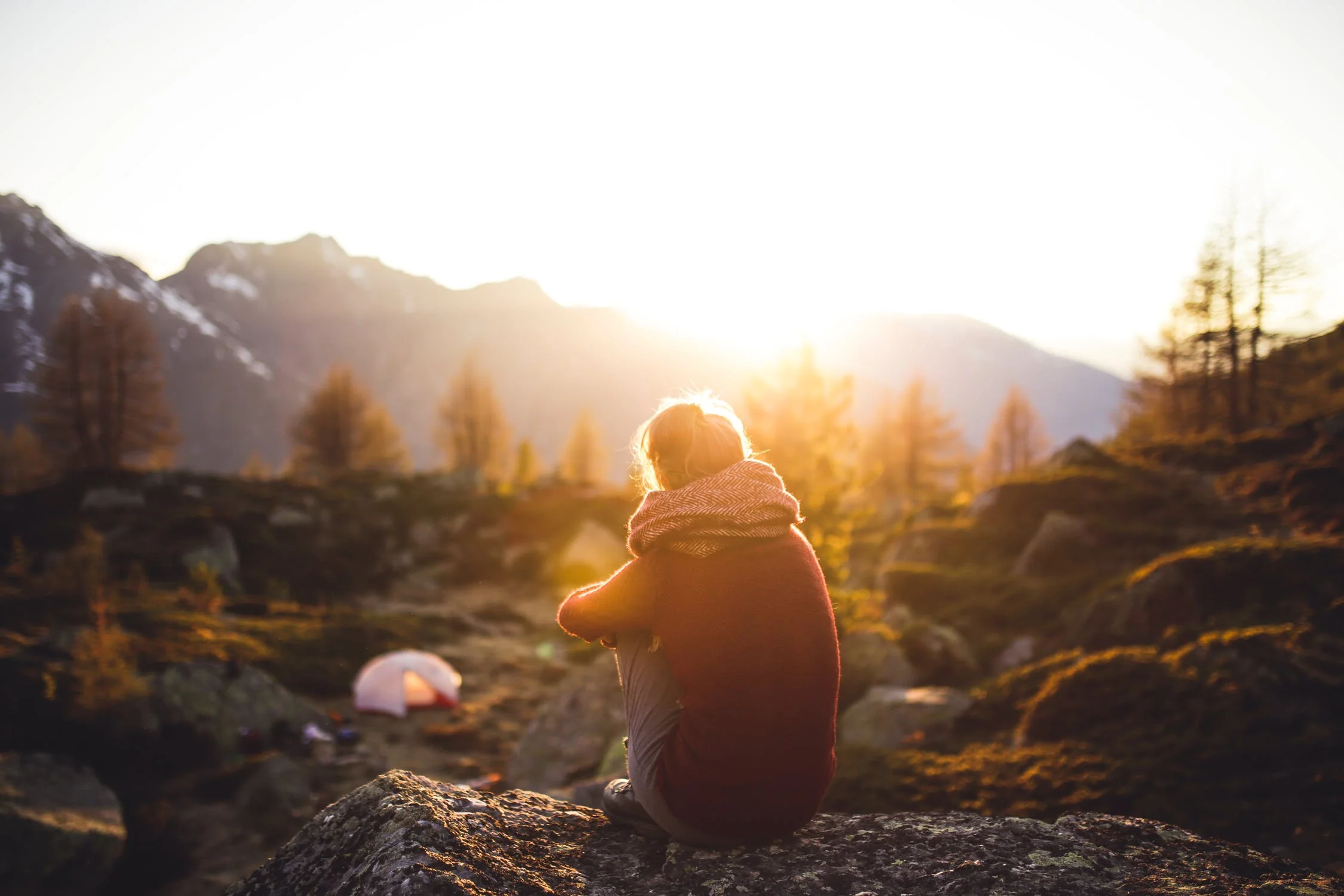 Woman sits at campsite and practices mindfulness
