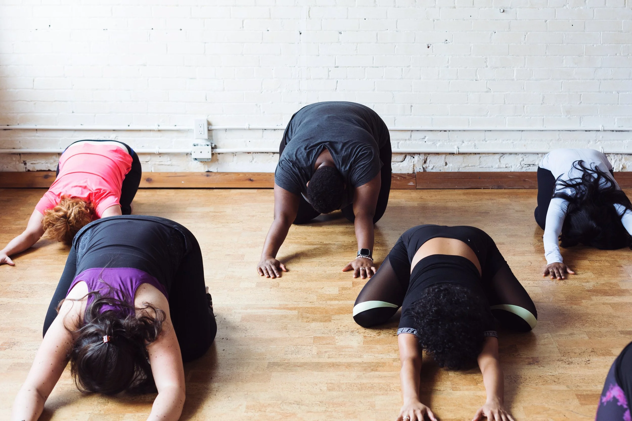 Yoga Class Practices Child’s Pose as Group