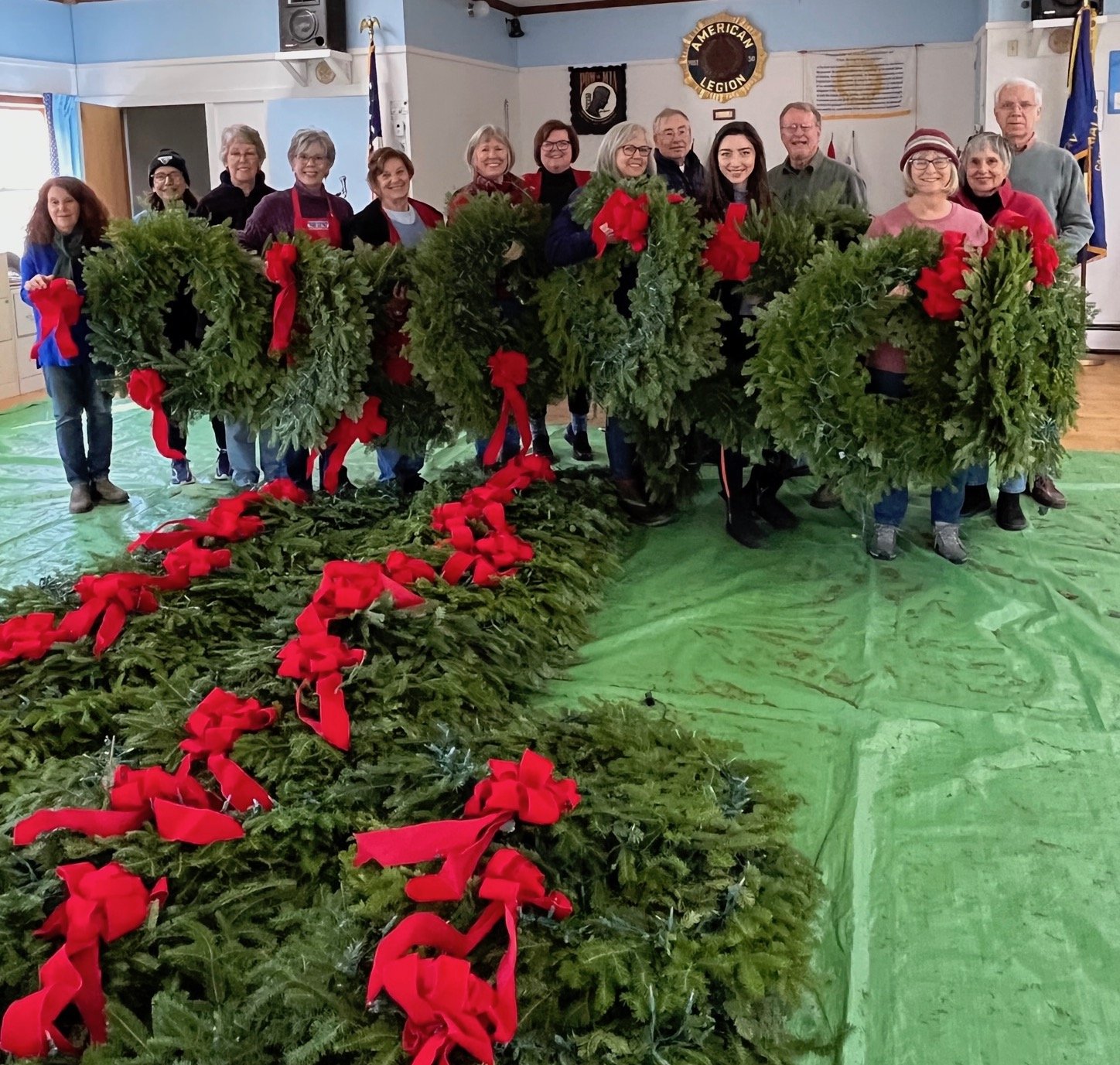 98 fresh balsam wreaths are completed with handmade crimson felt bows and strings of warm white lights for hanging downtown by Camden Garden Club members.