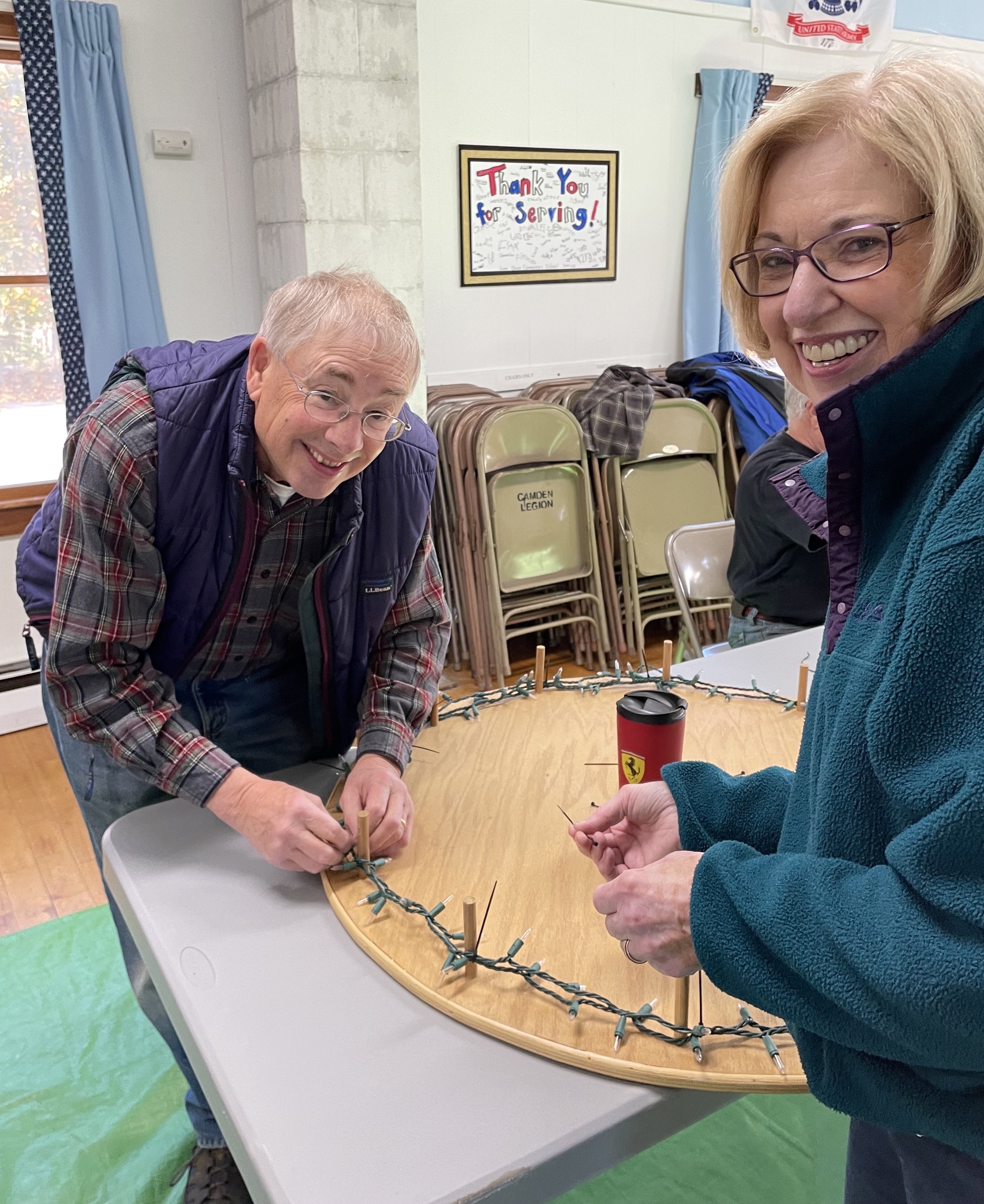 Camden Garden Club members use wooden frames to make the light loops for the 98 downtown lamppost wreaths.