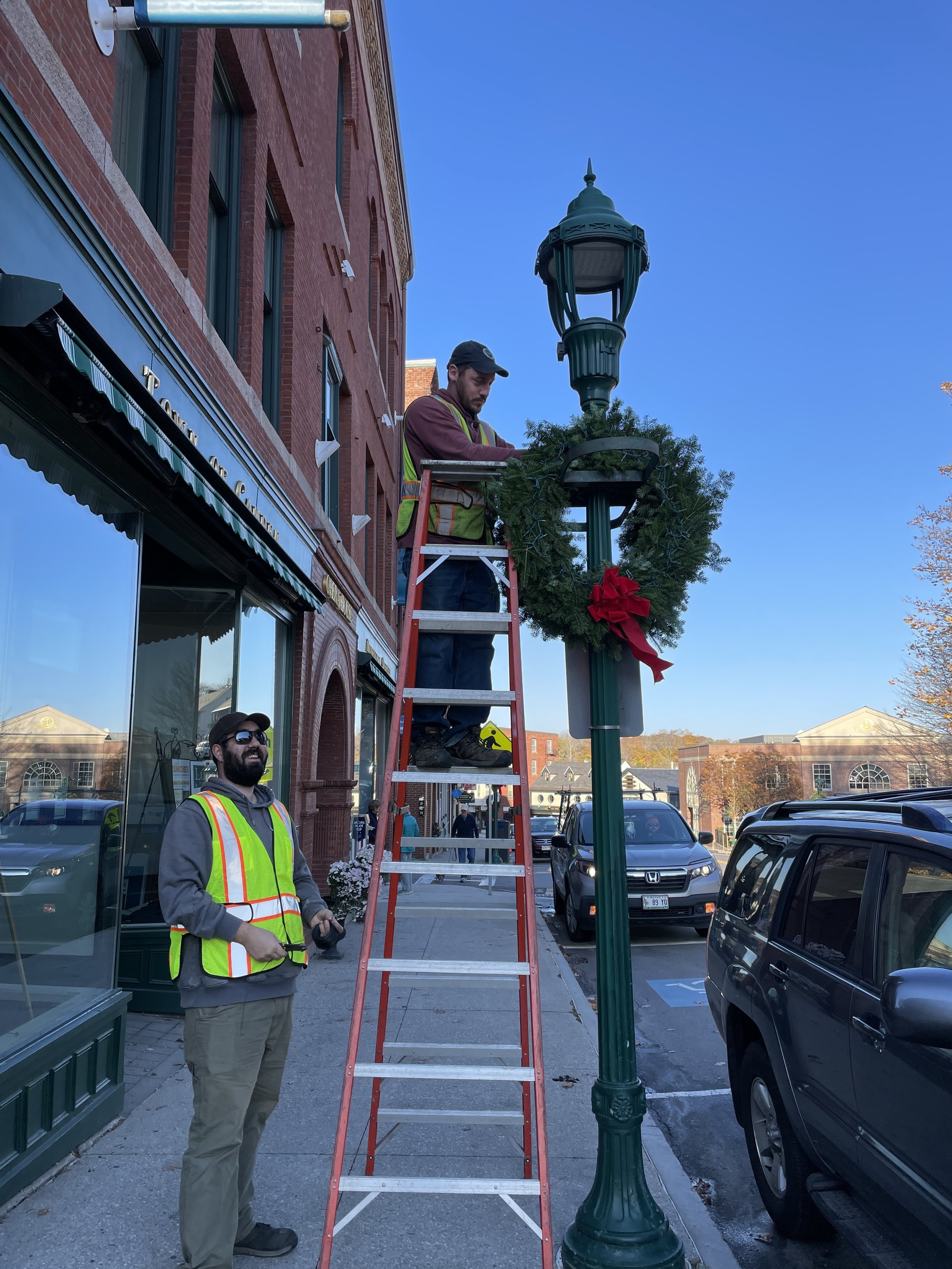 Employees of the Town of Camden putting up the Camden Garden Club wreaths in 2021. 