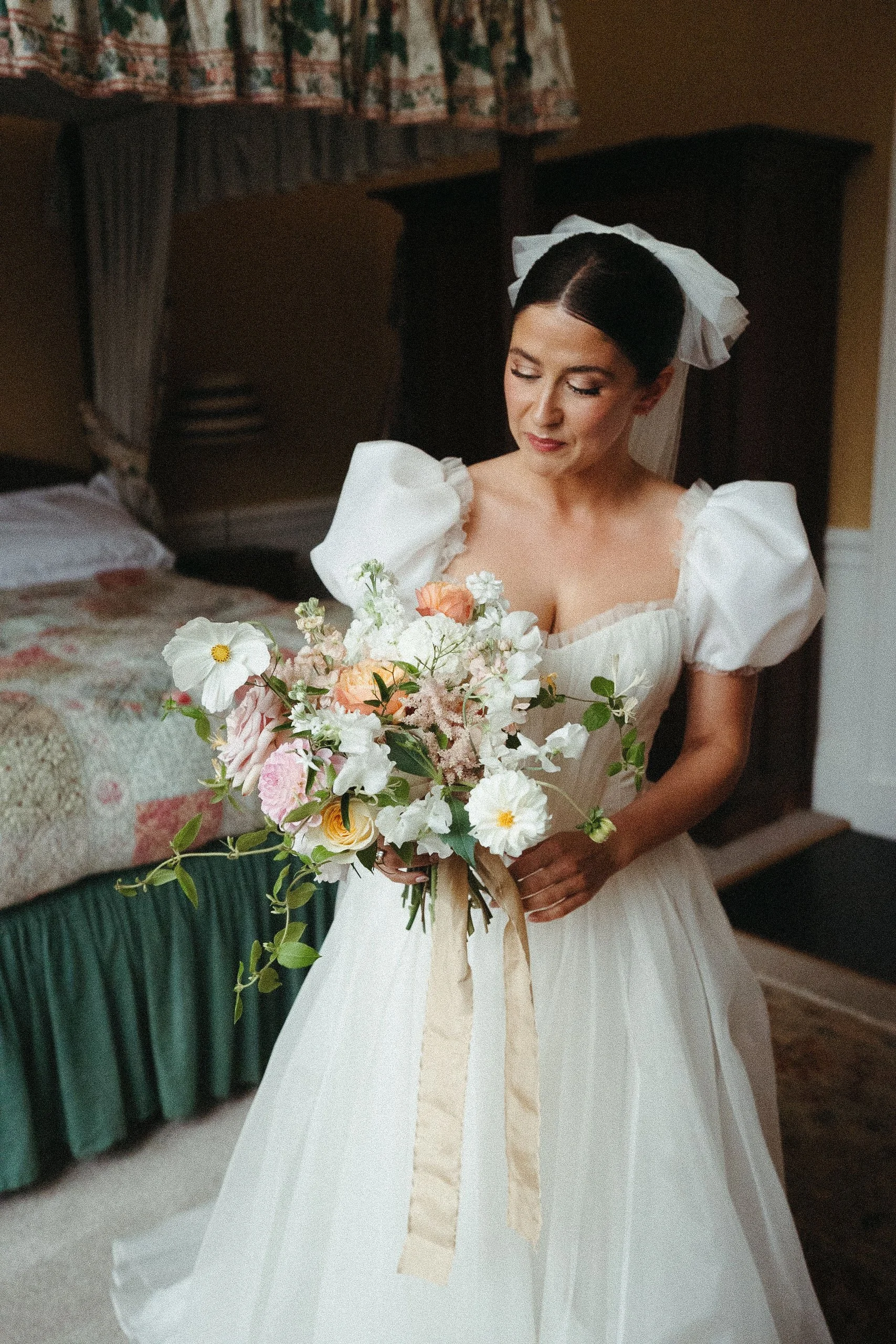 Bride wears an organza bespoke wedding dress by wilden london with cute short puff sleeves and delicate frills, with a full silk organza skirt.