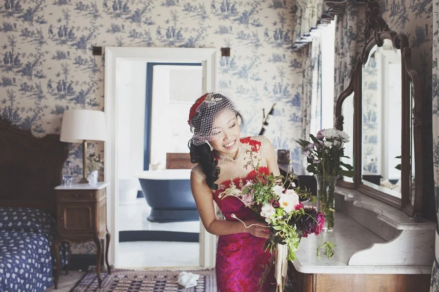  a chinese bride wears a red bridal cheongsam wedding dress made from red and pink vintage silkscreen printed silk. 