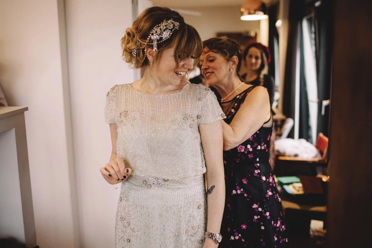  a bride wears a sage green wedding dress embroidered with rain-like lines of silver beads, swarovski beads create floral motifs 