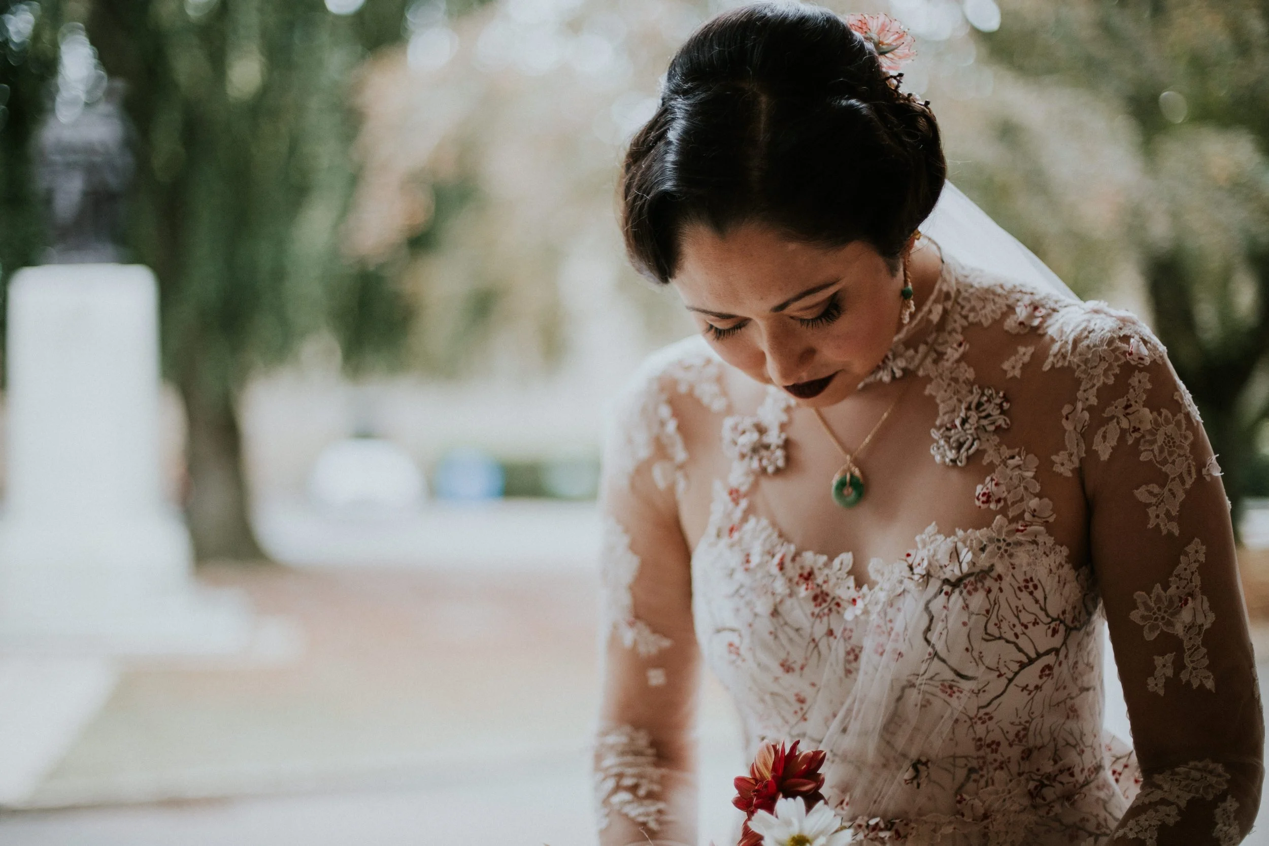  a chinese bride wears a bridal cheongsam wedding made from vintage silkscreen printed silk featuring a cherry blossom print design. 