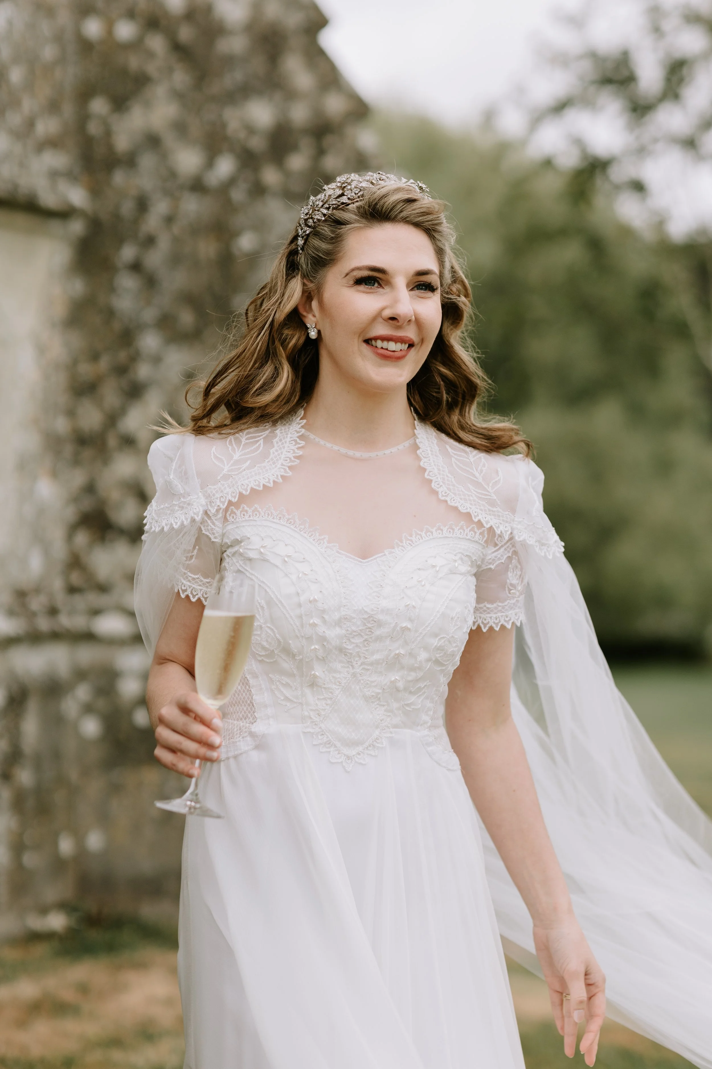 a hand embroidered wedding dress and cape using personalised motifs to represent the bride and groom. florals from each of their homes