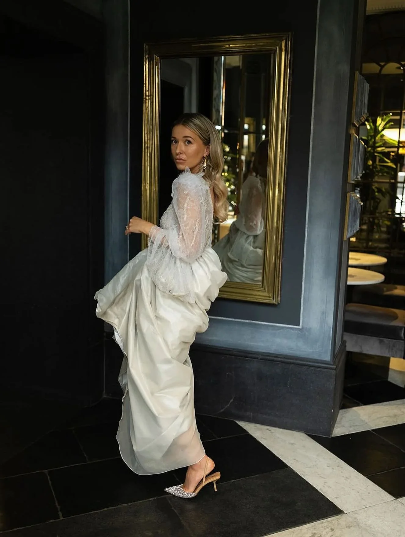 This silver lace gown shaped by mood and modern bridal styling. An a-line ballgown skirt in luminescent lame silk, softened with a textured chiffon, scooped and twisted into a tulip shape gives versatility, changing the dress from ceremony to black t