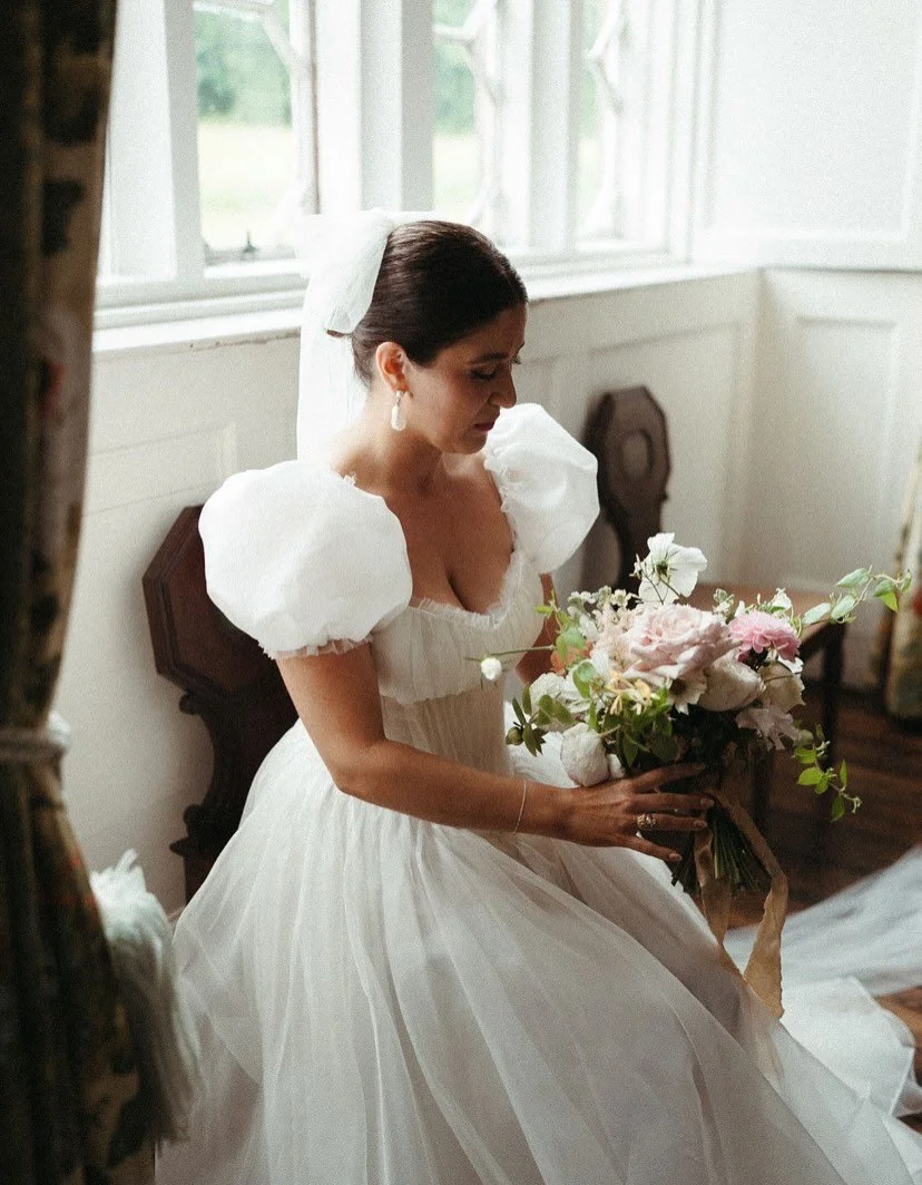 Ellie in her bespoke Wilden London wedding dress.

Designed with softly sculpted puff sleeves, a romantic basque waist, and delicate gathered pleat detailing through the bodice, the silhouette and structure and softness. #Layers of silk organza fall 