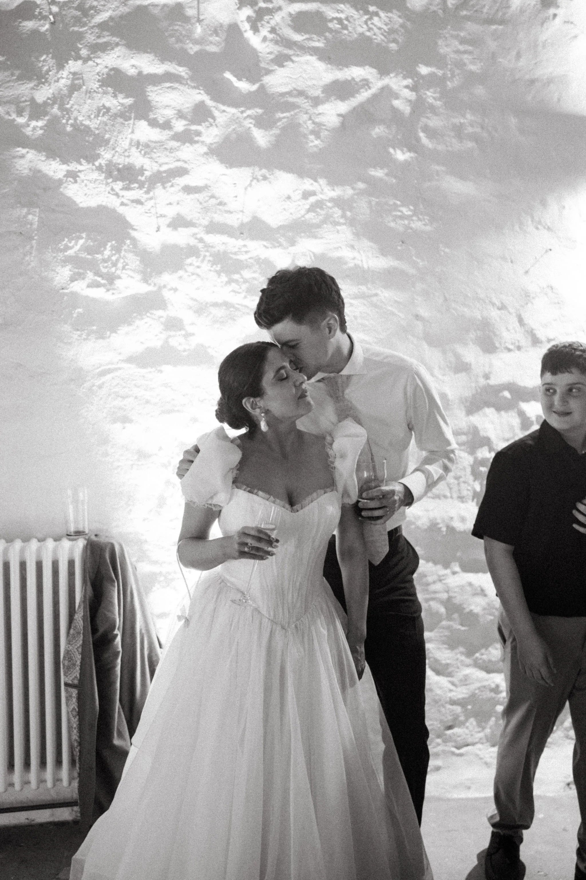 a bride and groom enjoy the last moments of their wedding. the bride wore her wedding dress all day - a silik organza gown  with puff sleeves and pleated and gathered material.