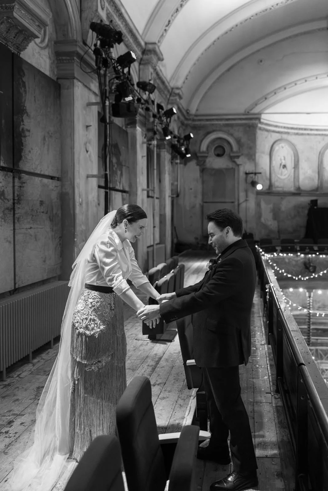 A bride and Grooms first look at Wiltons Music Hall in London. The bride wears a gown with an ivory silk blouse, and fringing skirt by Wilden London.