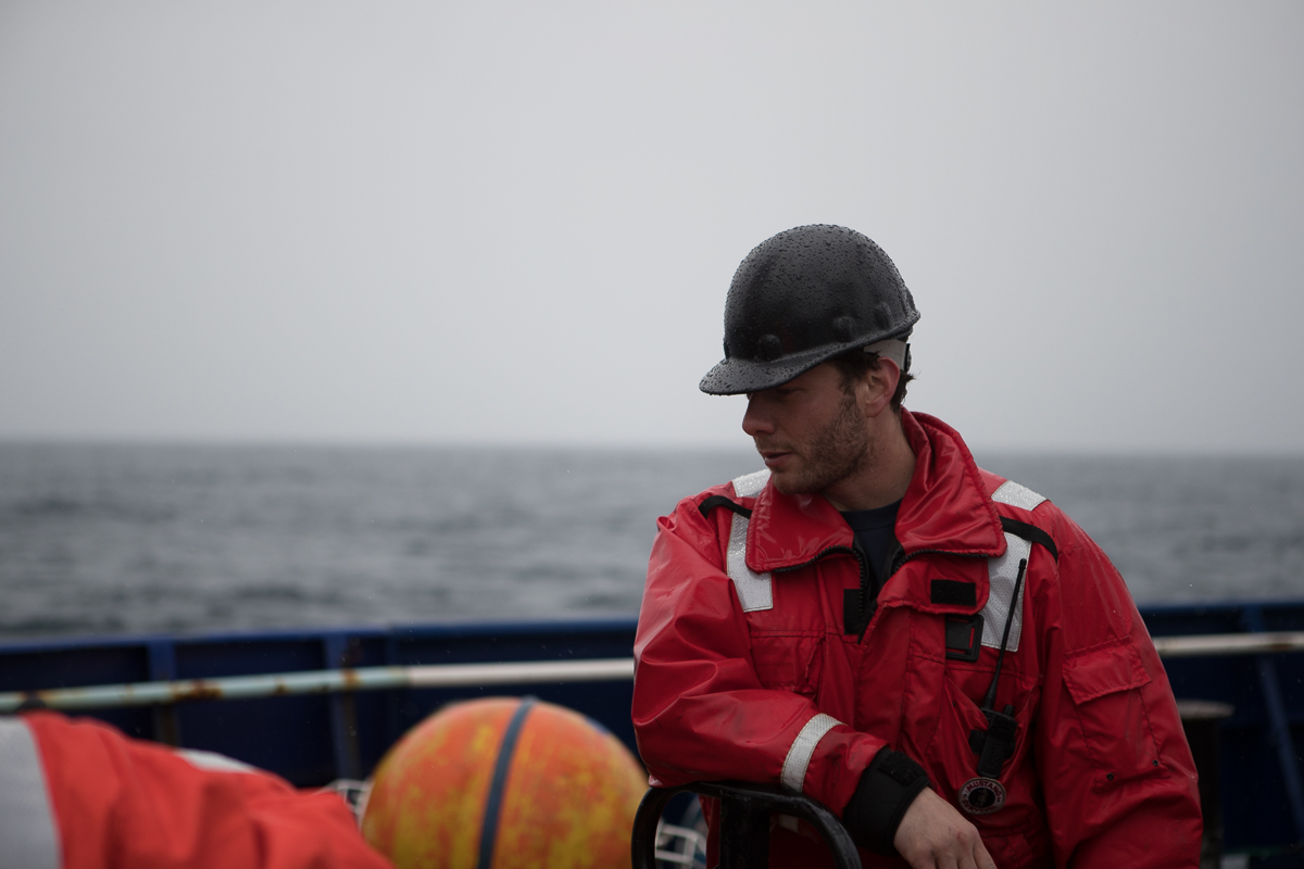 Ethan Roth observes some of the mooring equipment splayed out on the aft deck of R/V Sikuliaq . Photo credit: Brendan Smith