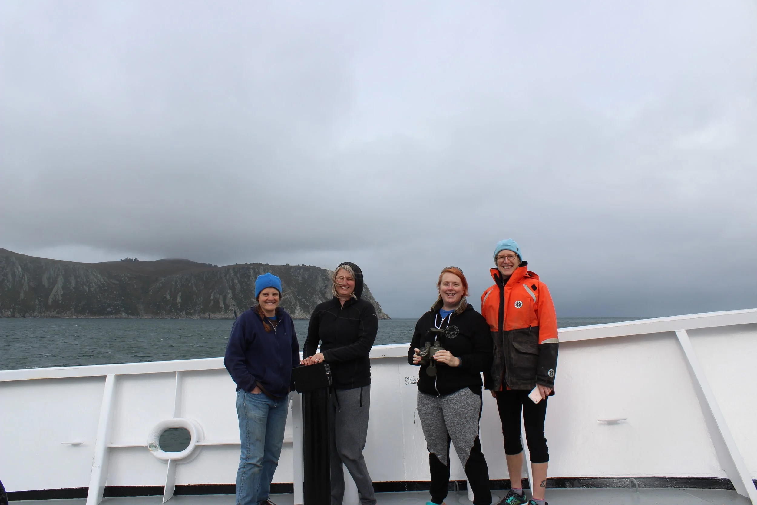 Left to Right: Catherine Berchok, Cathleen Vestfals, Nissa Ferm, and Libby Logerwell, out on bow in front of King Island in the northern Bering Sea. Photo credit: Harmony Wayner