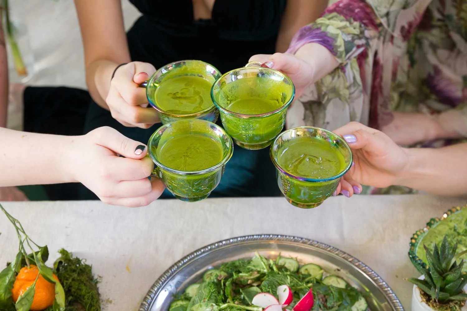 The group says cheers with vintage glasses filled to the brim with soup.