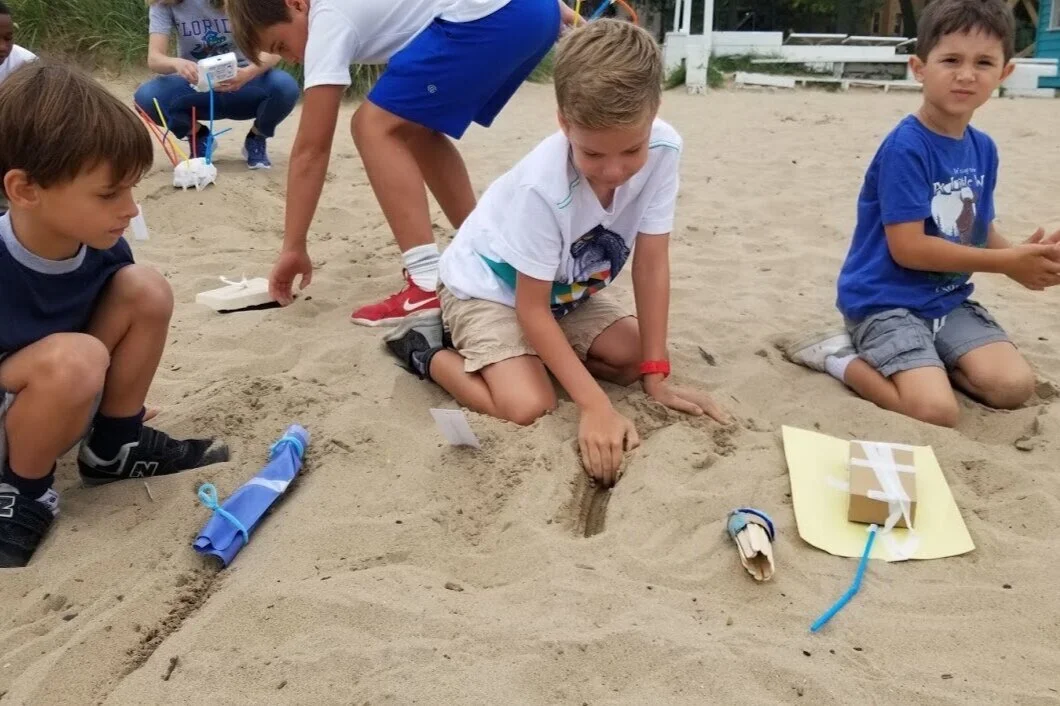 Redwood Day students testing the sand’s natural temperature.