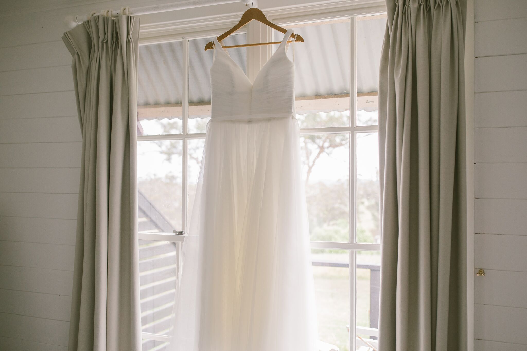 Wedding dress hung up on a window in Mali Brae Farm Wedding