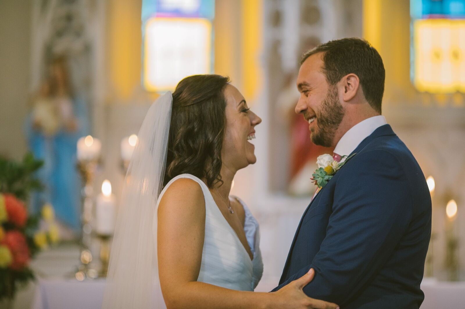 Bride and Groom laughing at the alter