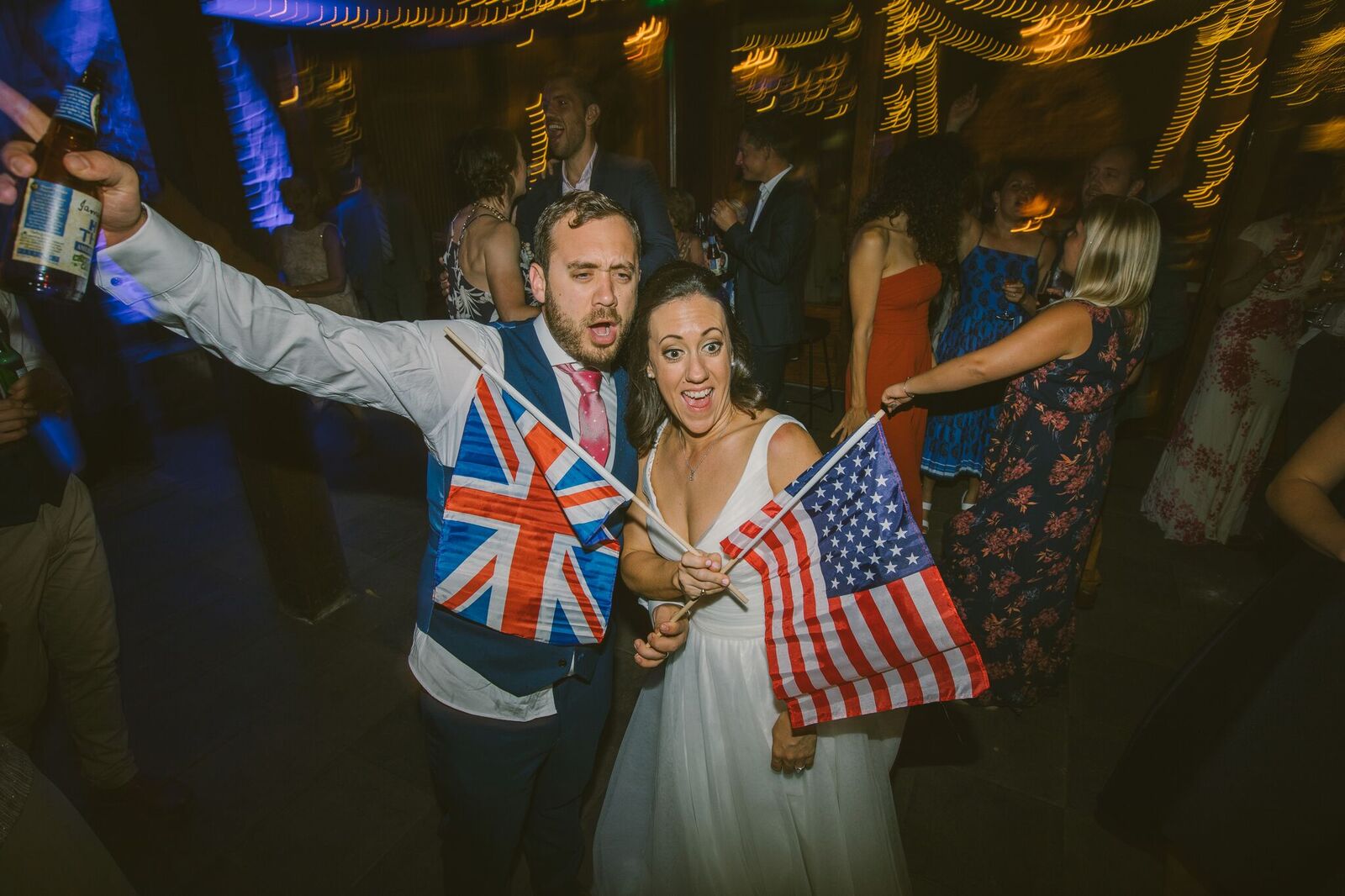 Bride and Groom holding an American and English Flag each