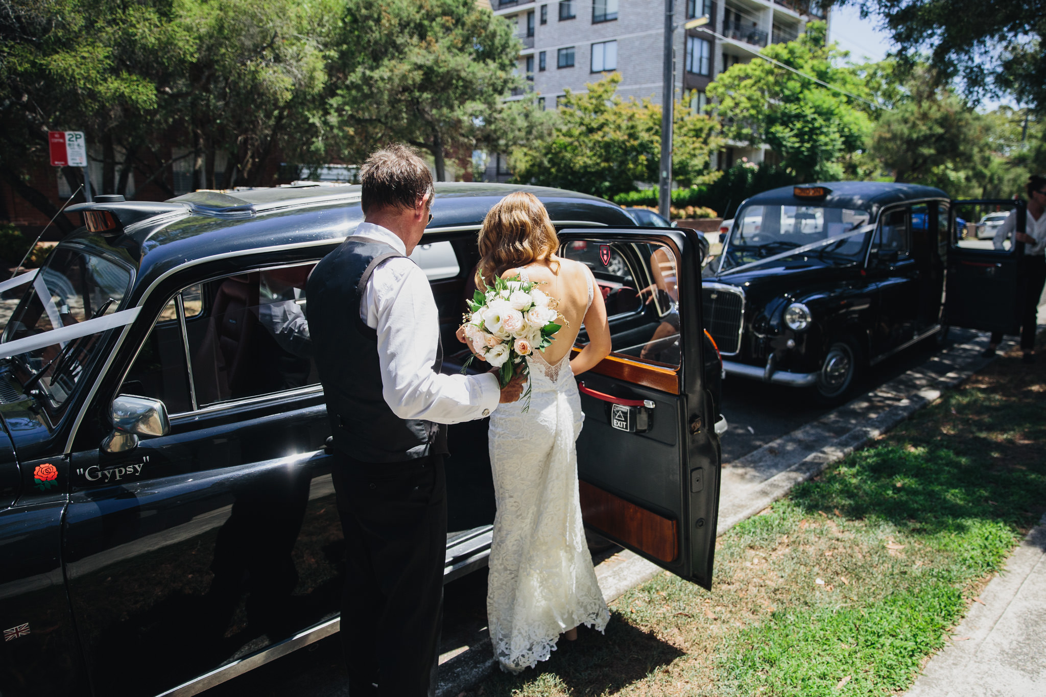 Bride getting into her wedding car a London taxi