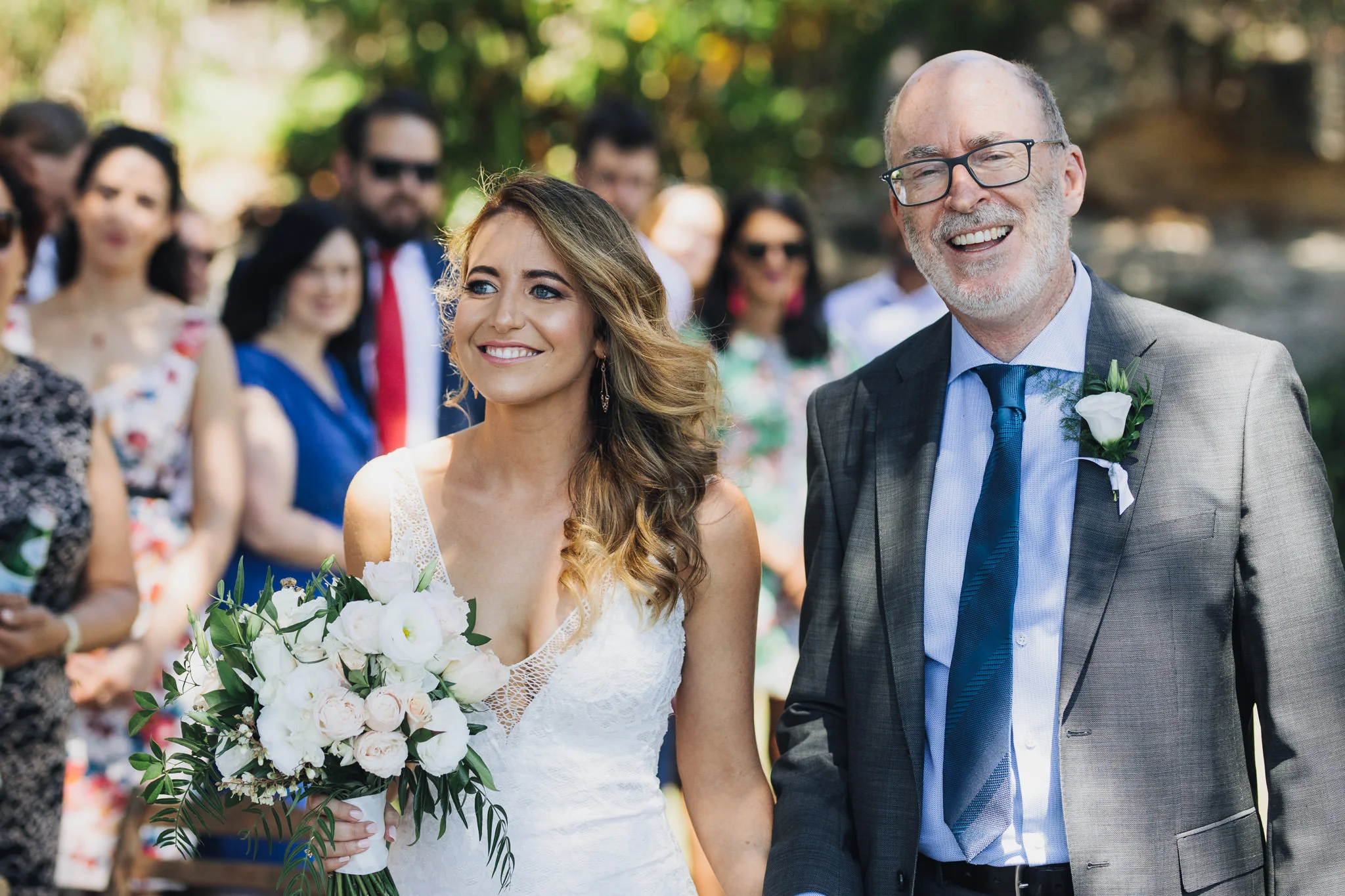 Bride smiling and walking in to her Sydney wedding on Sydney Harbour at The Botanical Gardens Harbour View Lawn