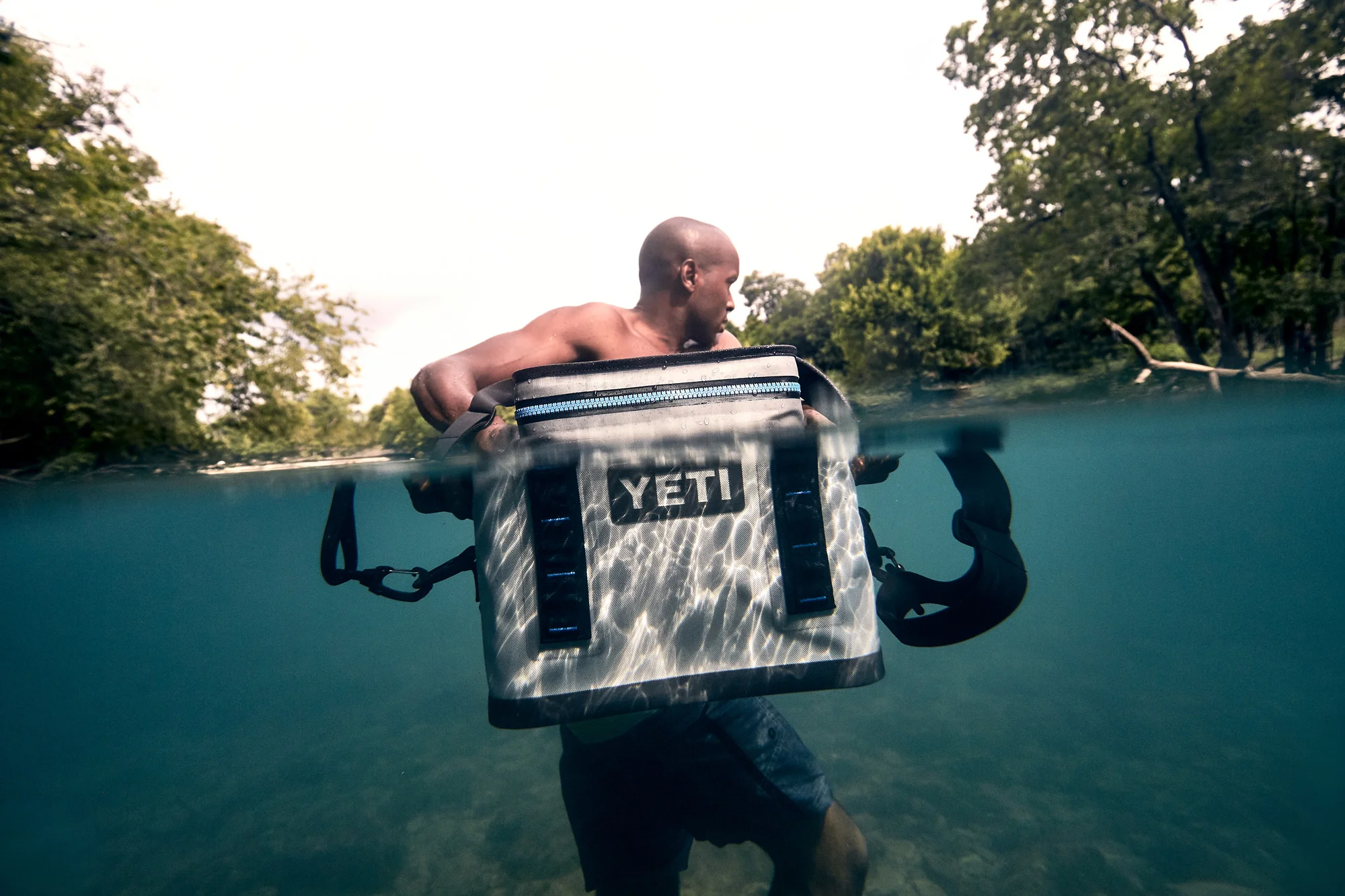 Man with YETI Hopper cooler underwater