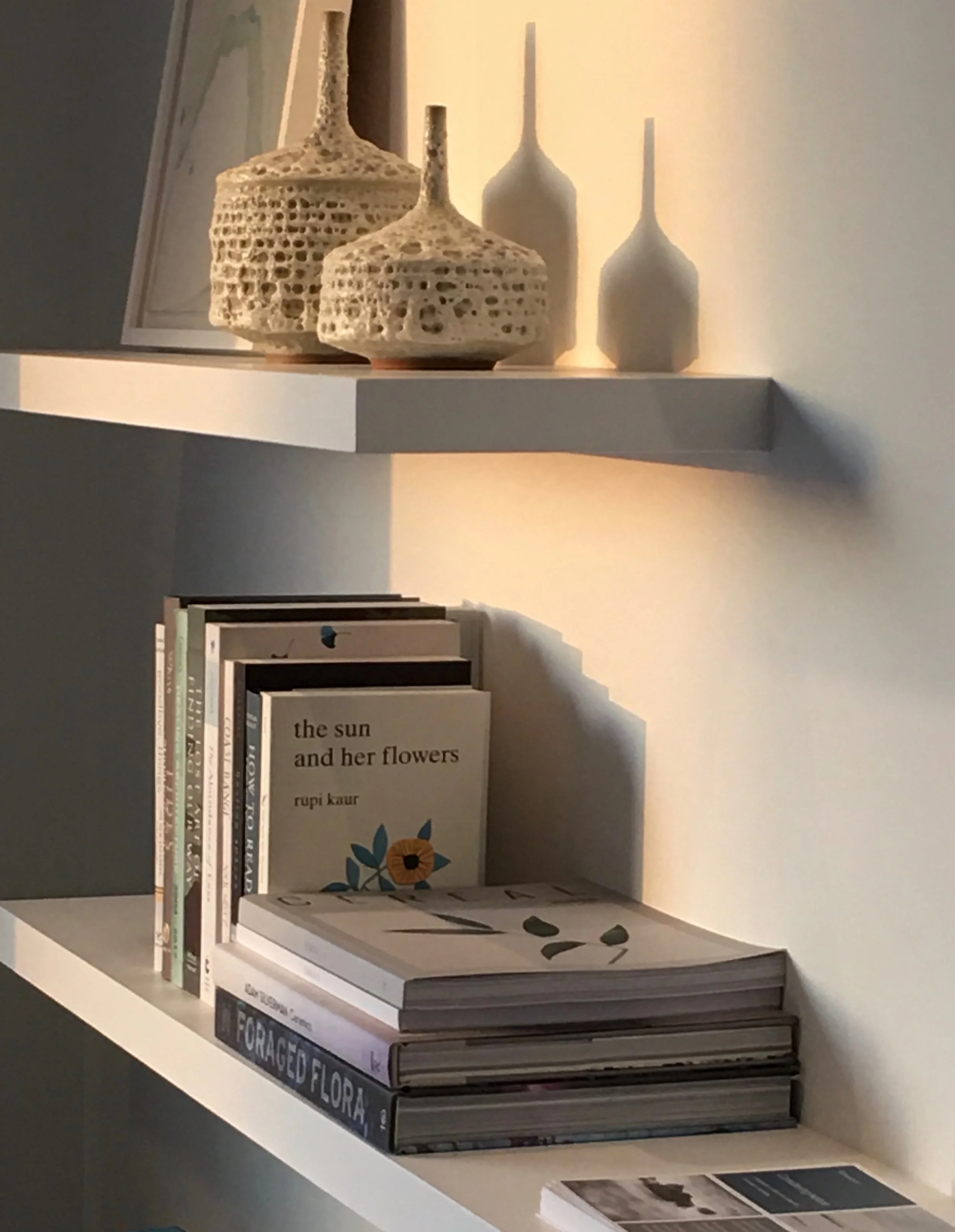 Light filled living room by Mead Quin. A few trinkets on the shelves.