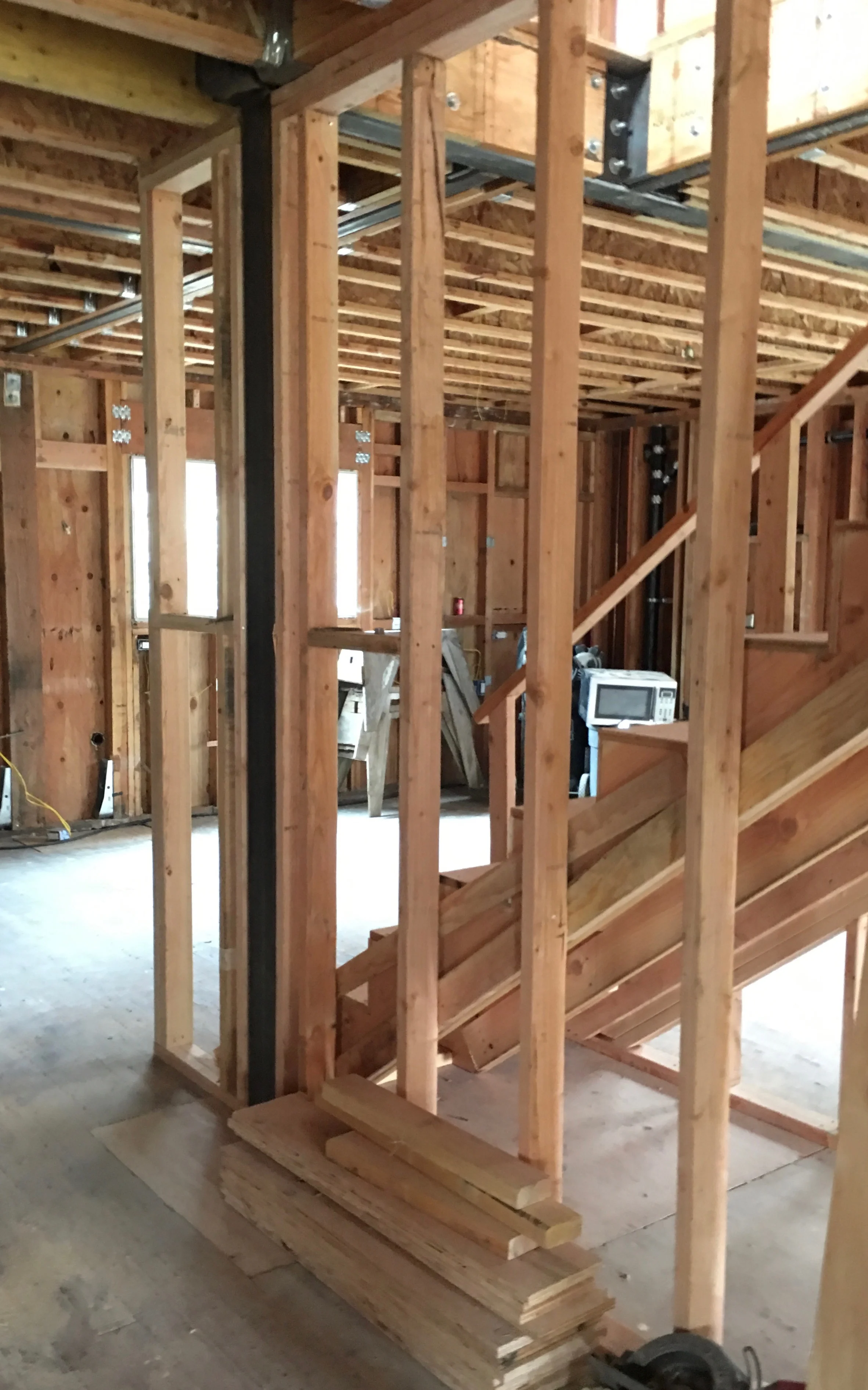 Stairs are turned towards the back of the house and framing for the Kitchen wall has begun. Turning the stairs and moving the Kitchen allowed for space at the back of the house for a nice Family Room facing the garden.