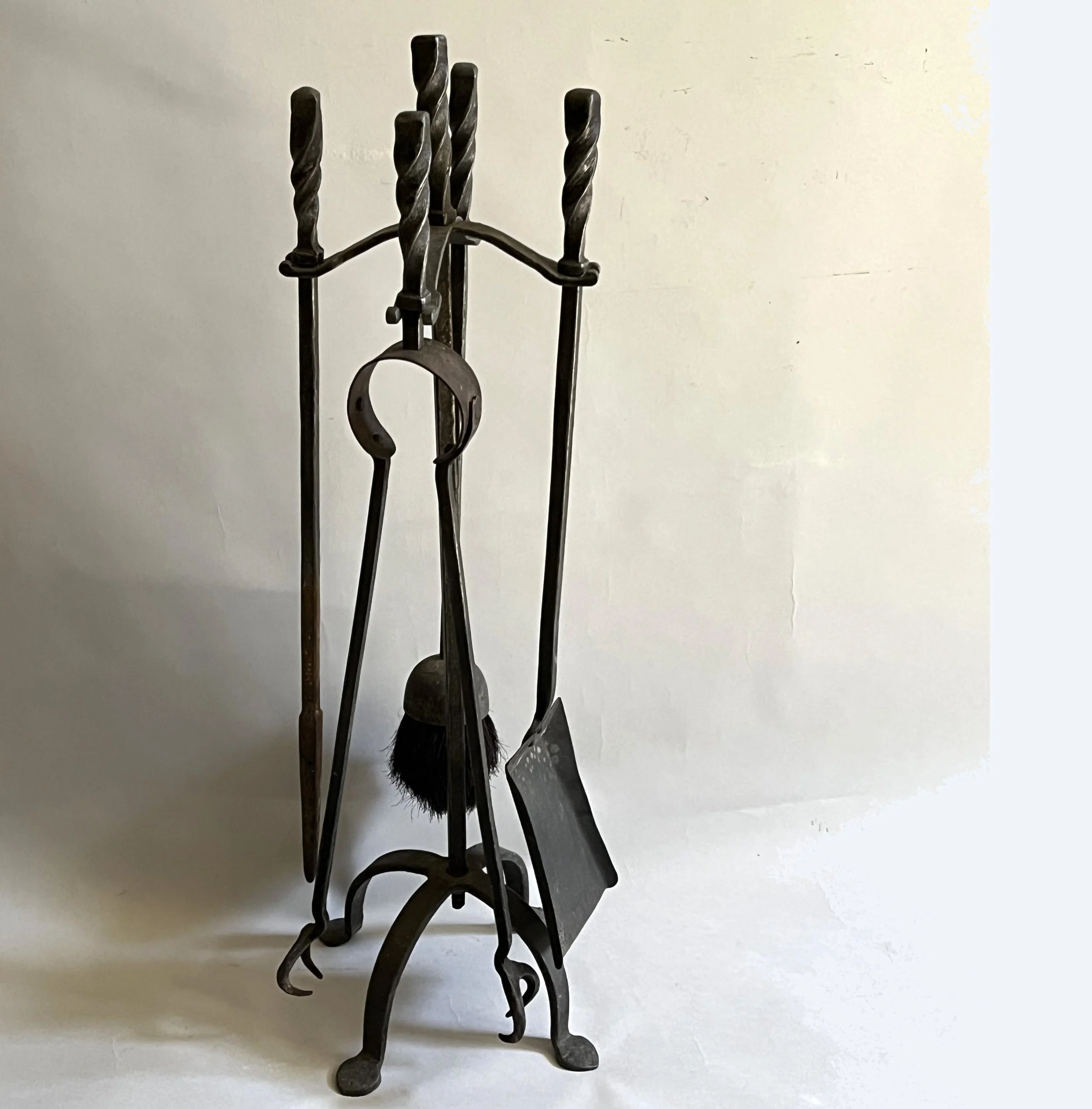 A set of 20th century English wrought iron firetools with stand