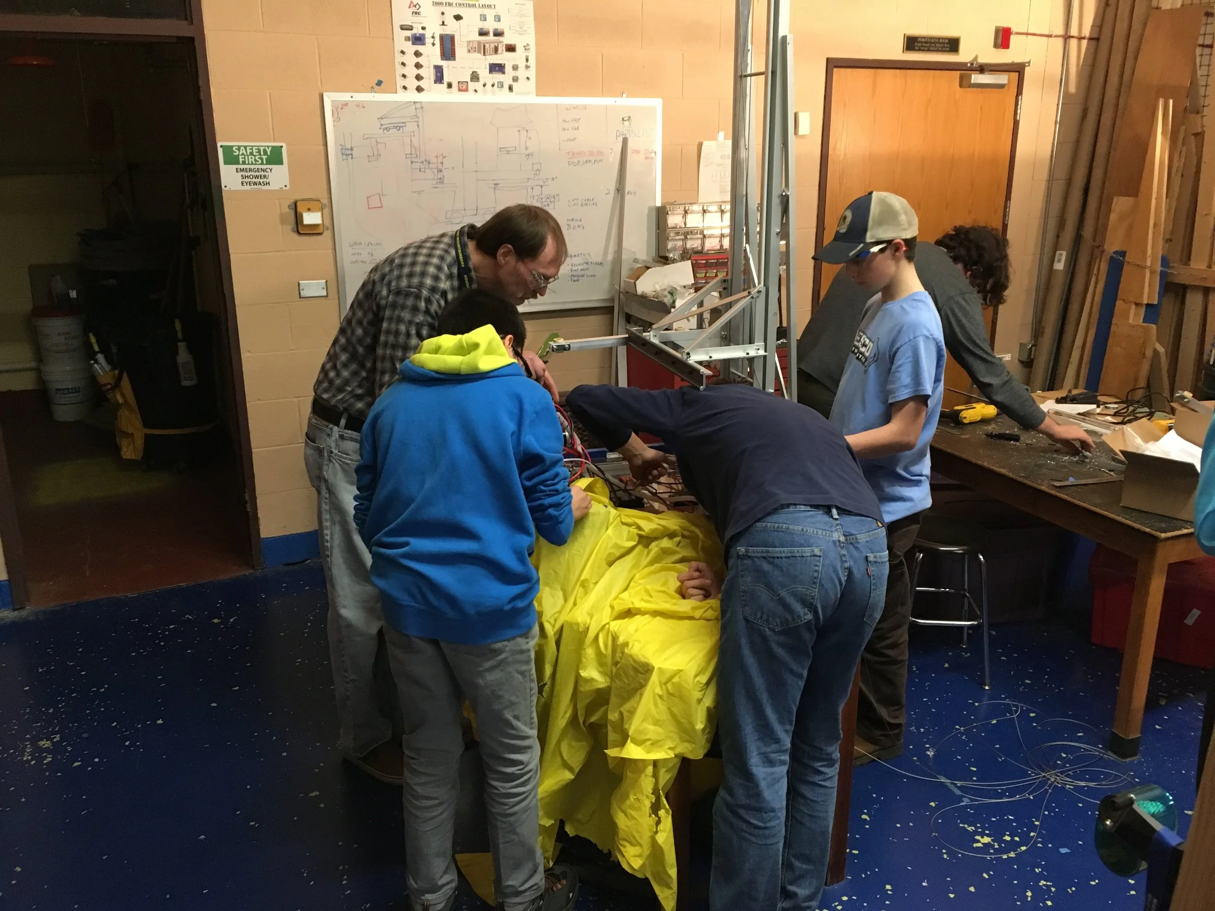 The build team, cutting metal, being very careful not to get shavings in the drive or electrical components.
