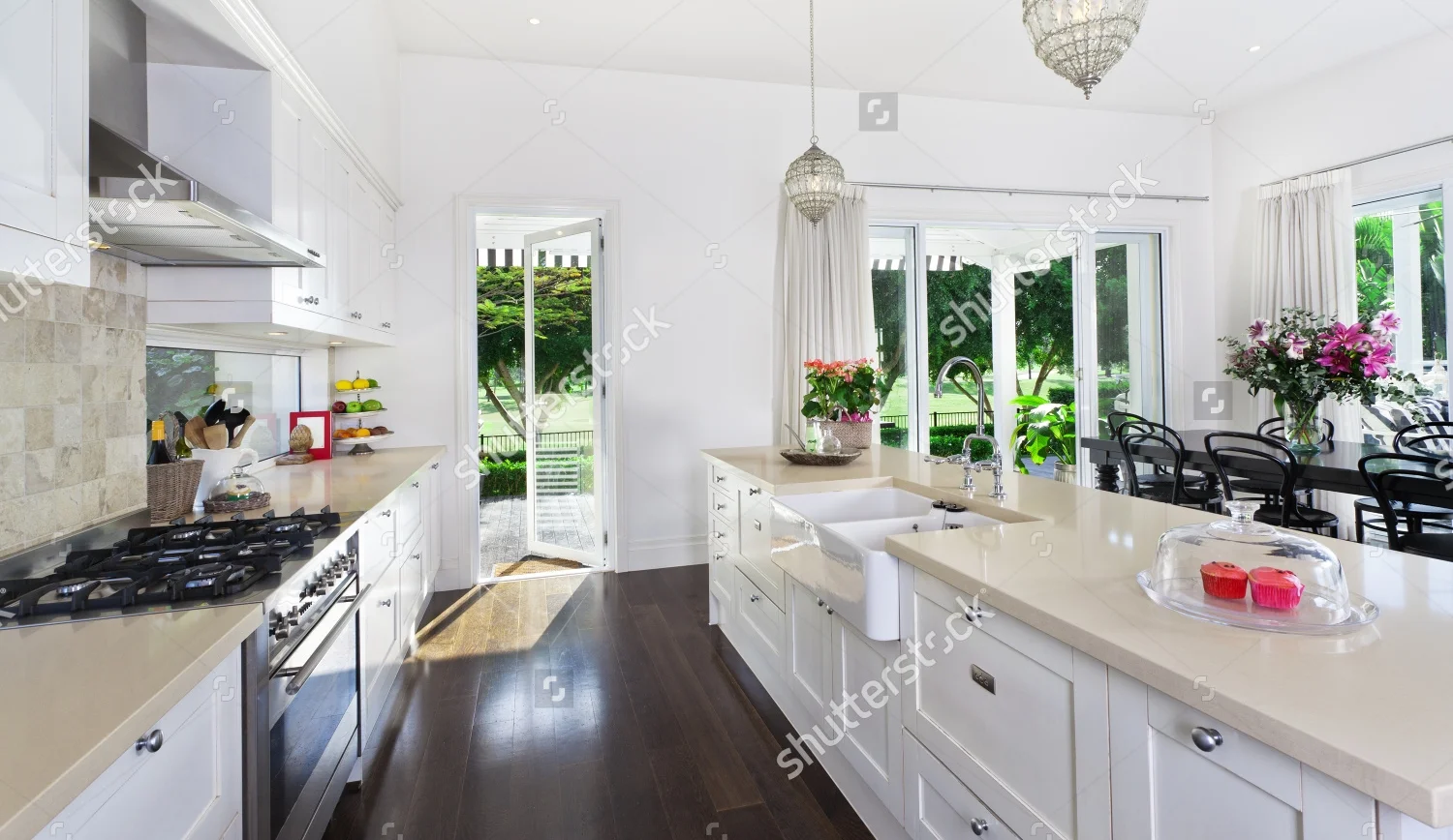 stock-photo-stylish-open-plan-kitchen-with-stainless-steel-appliances-and-dining-area-overlooking-a-pool-and-88505629.jpg
