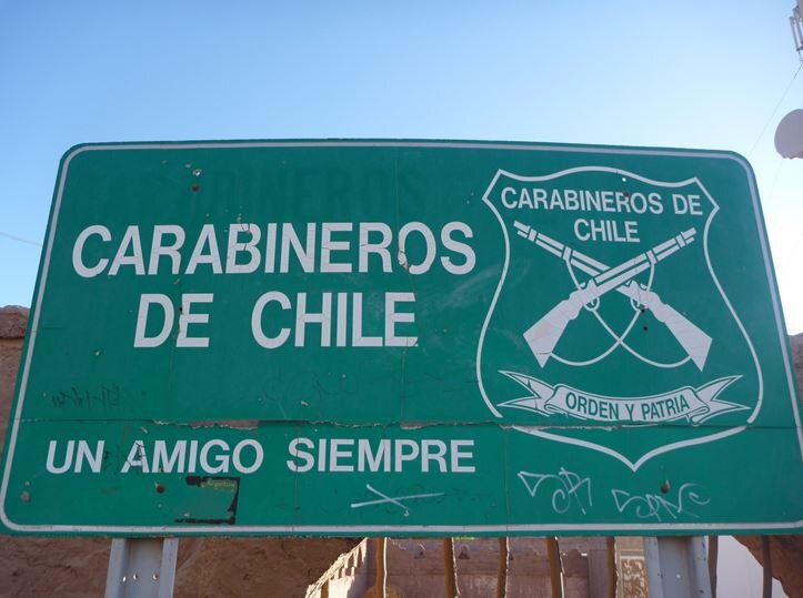 A road sign by the Carabineros de Chile, with their now defunct slogan "un amigo siempre" ("always your friend") [Photo credit: Benjamin Dumas, 2011].