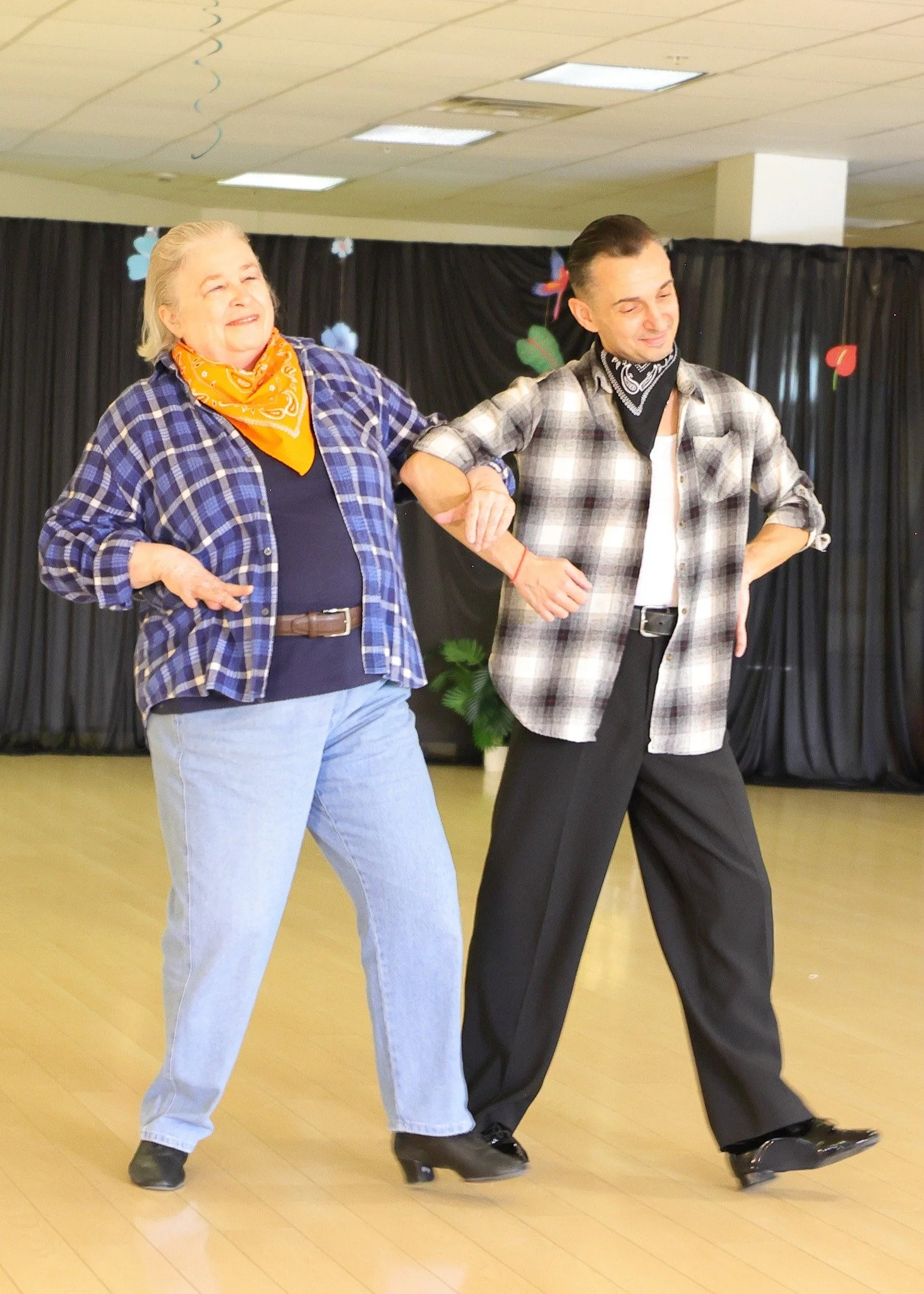 Two performers dance in checked shirts during a theatrical showcase routine