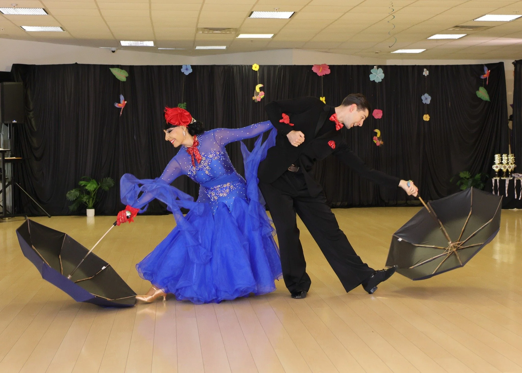 A couple performs a ballroom routine with a flowing blue dress