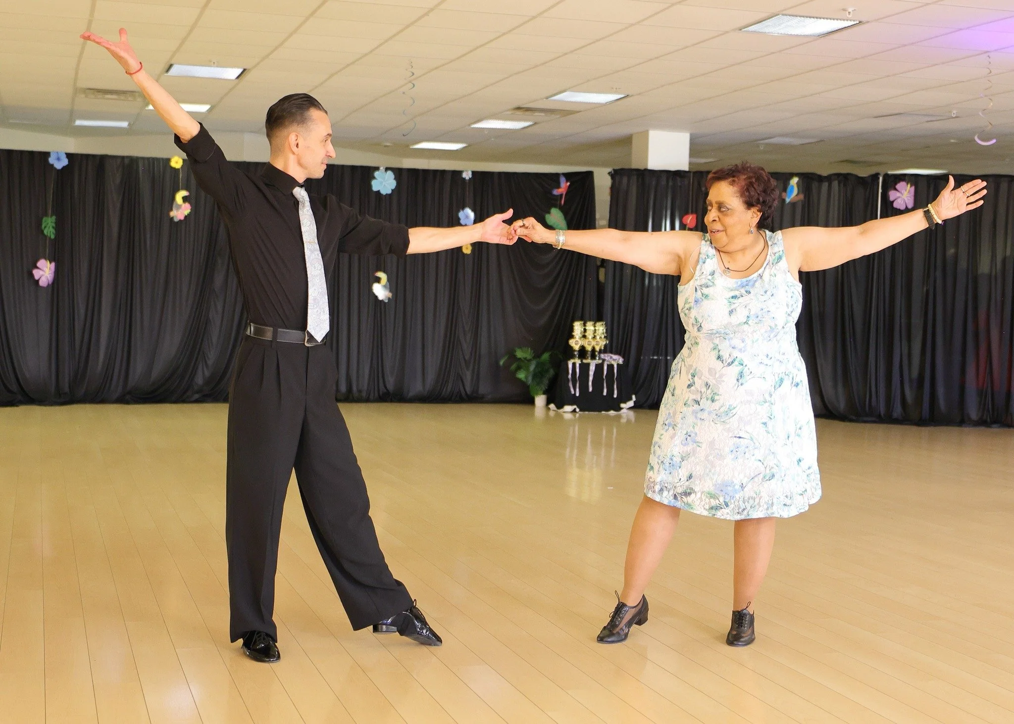 Showcase dancers extend their arms across the studio floor
