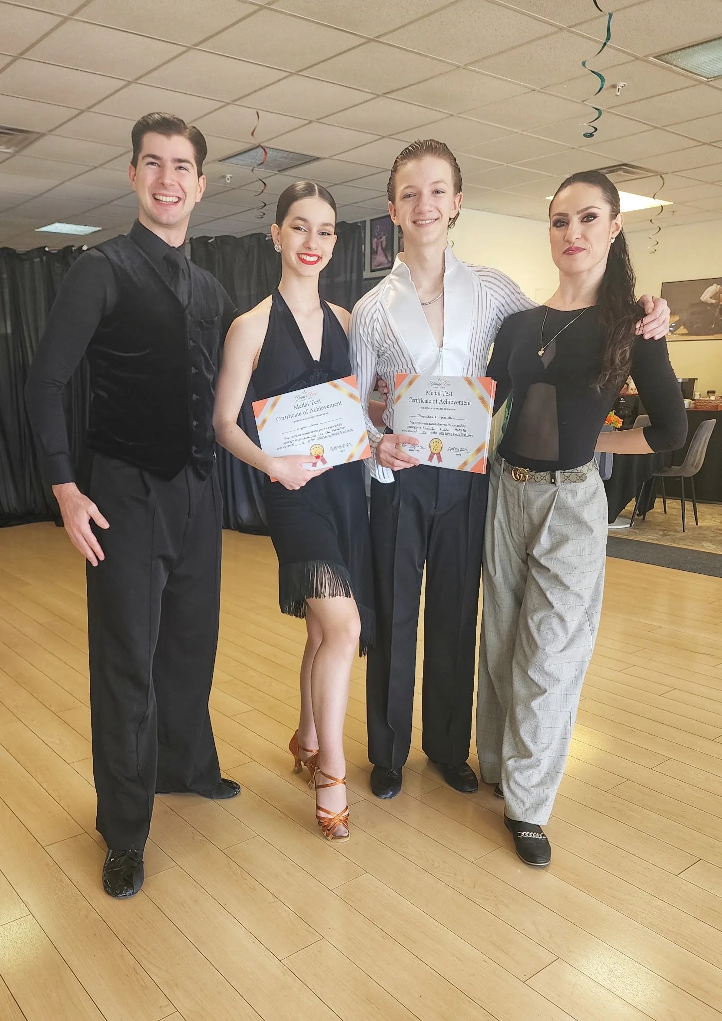 A student holds her certificate while posing with the Dance Fire team