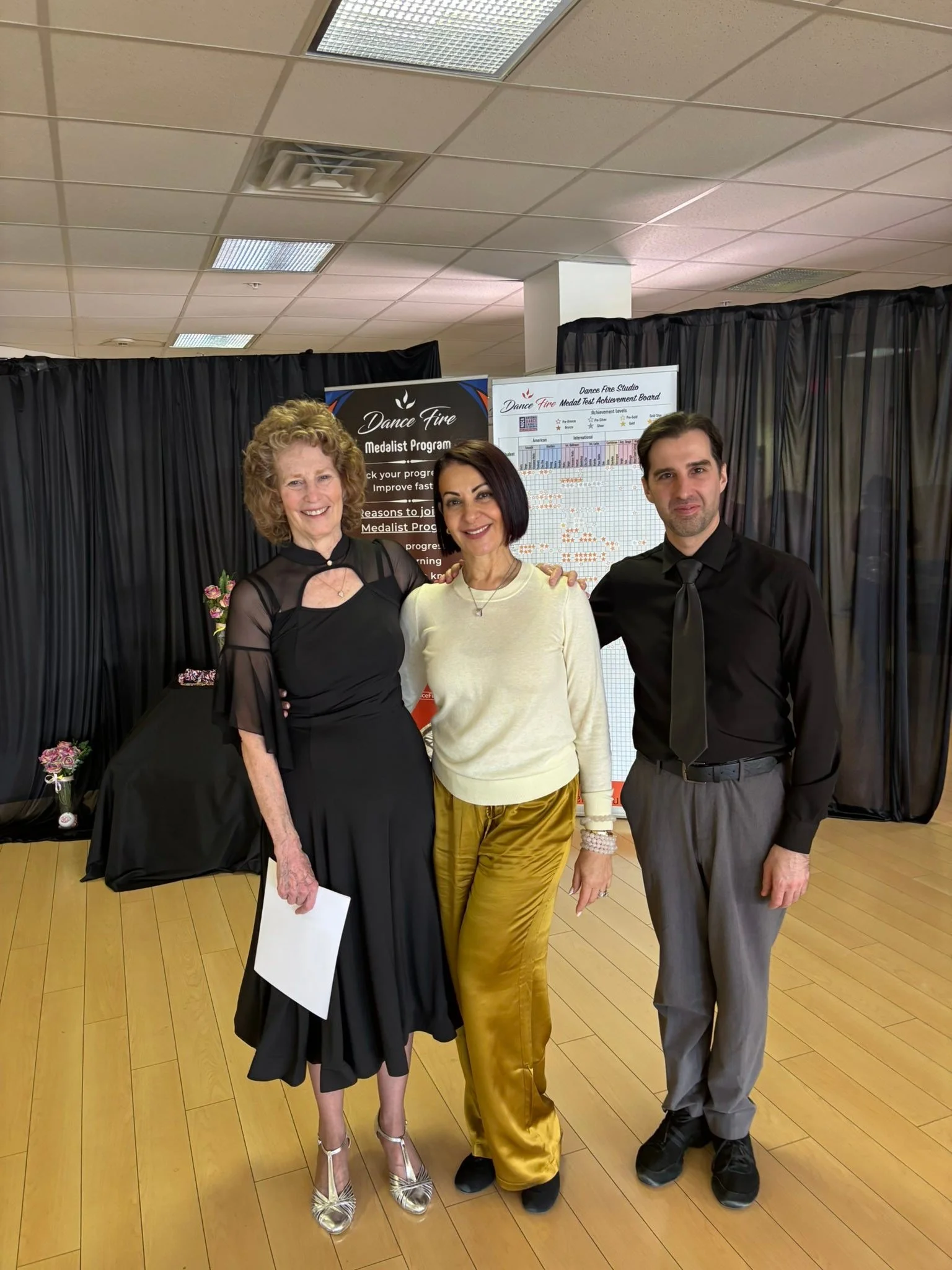 A spring event participant stands with the assessment team holding her results