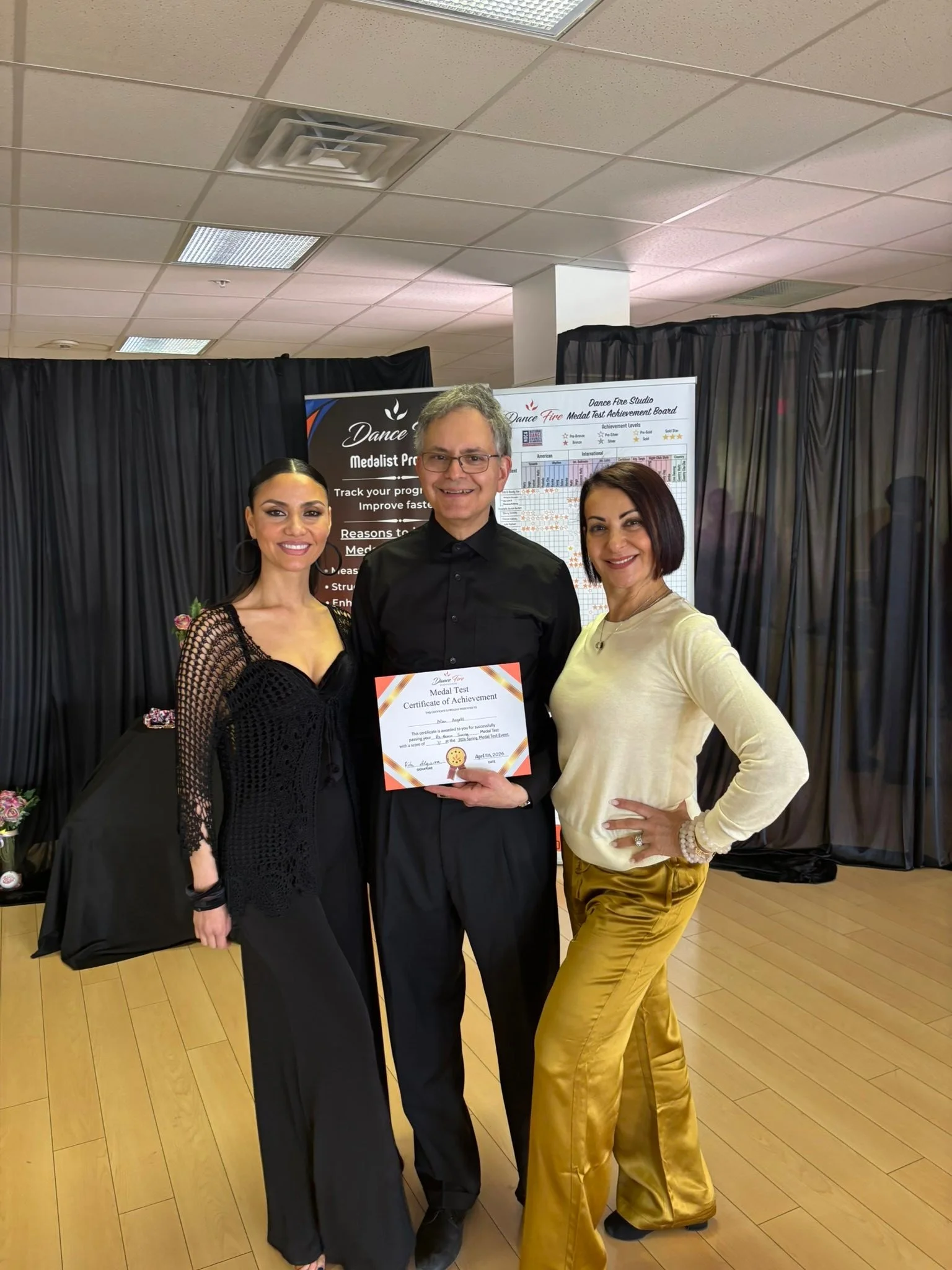 A Medal Achievement recipient displays a certificate with the Dance Fire team