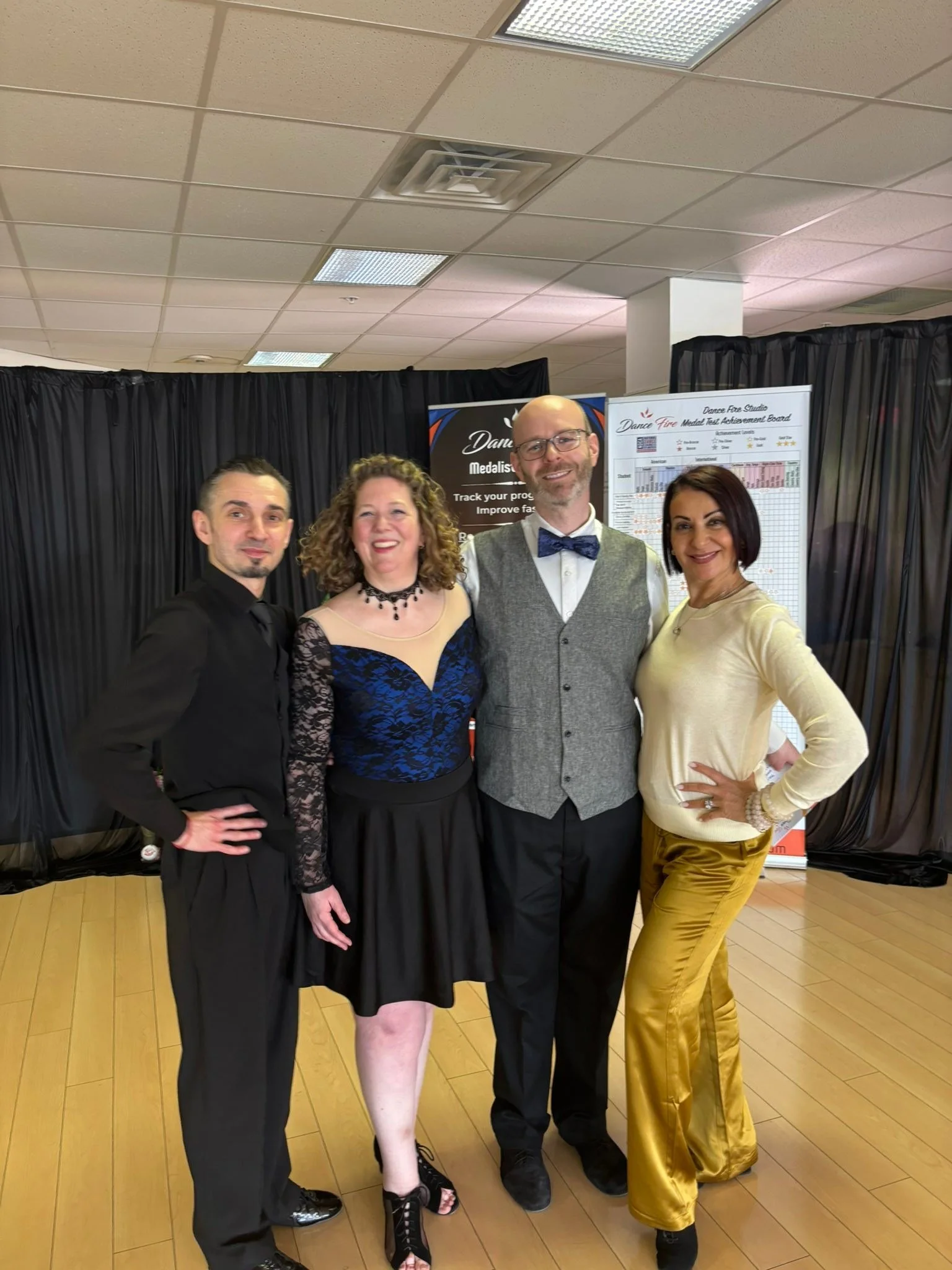 A dancer in blue poses with the spring Medal Achievement team