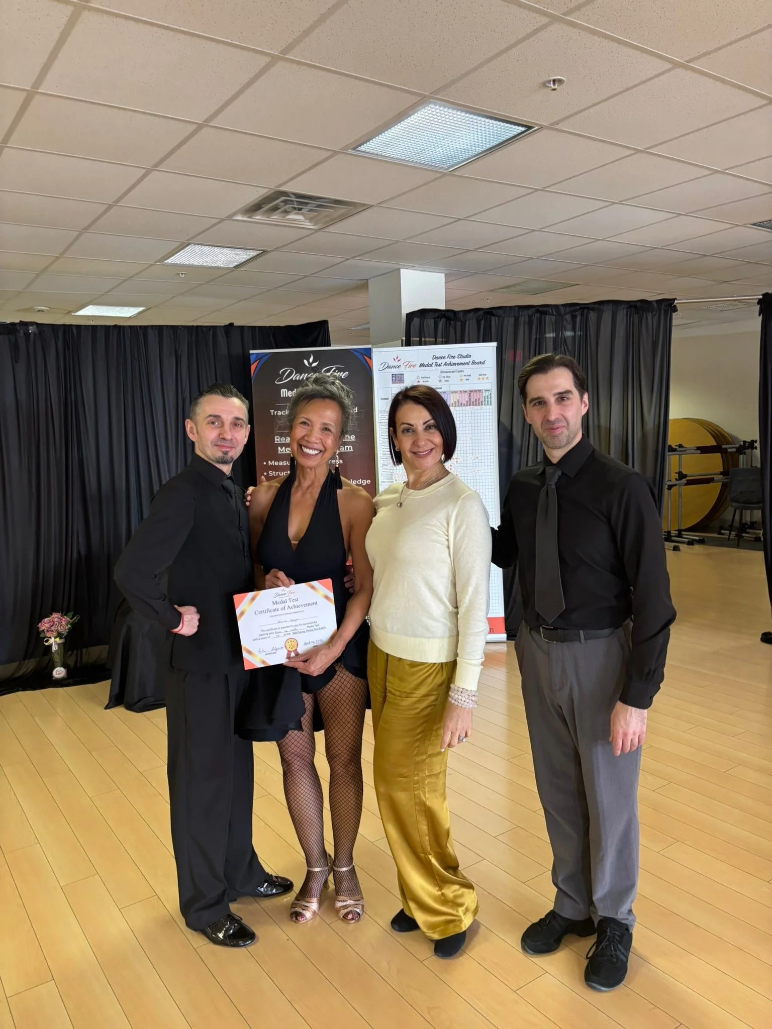 A spring Medal Achievement recipient poses with her certificate and studio team