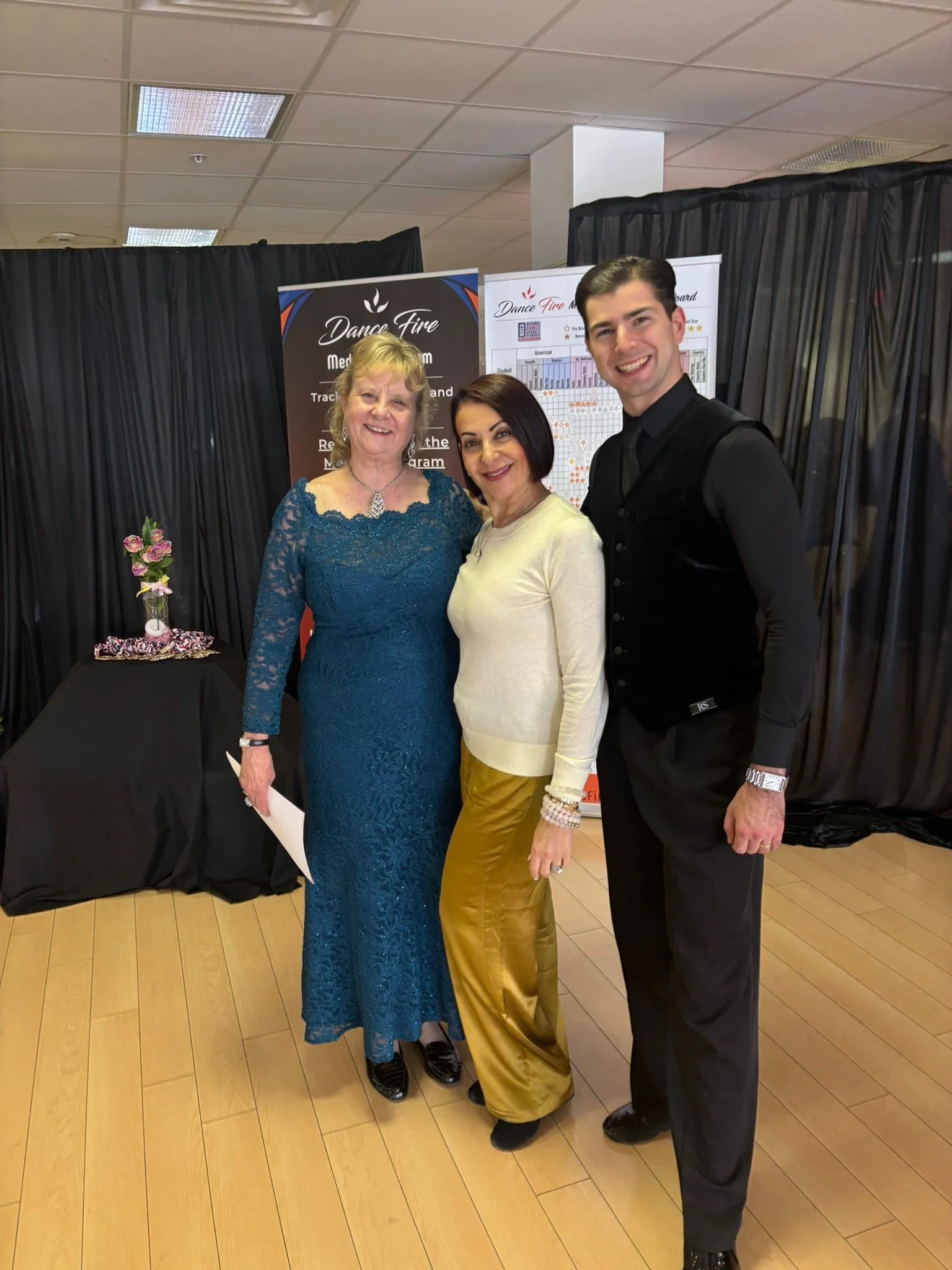 A dancer in blue poses with two members of the Dance Fire team