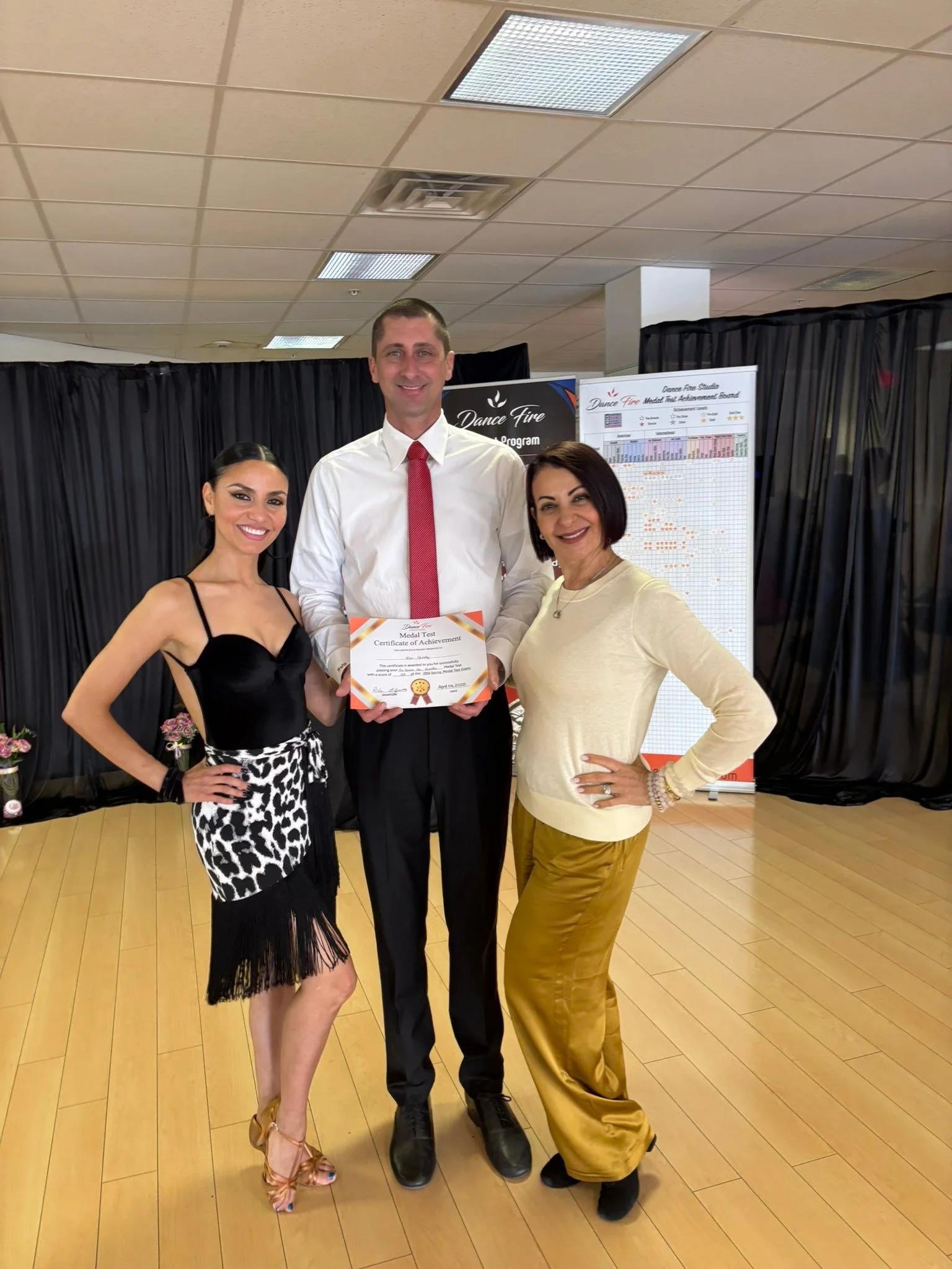 A spring event participant poses beside her dance partner and assessor