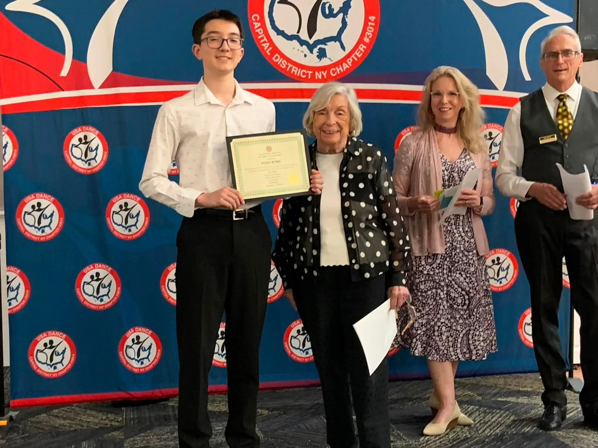 Evan and Niamh display their youth scholarship certificates with the award presenters