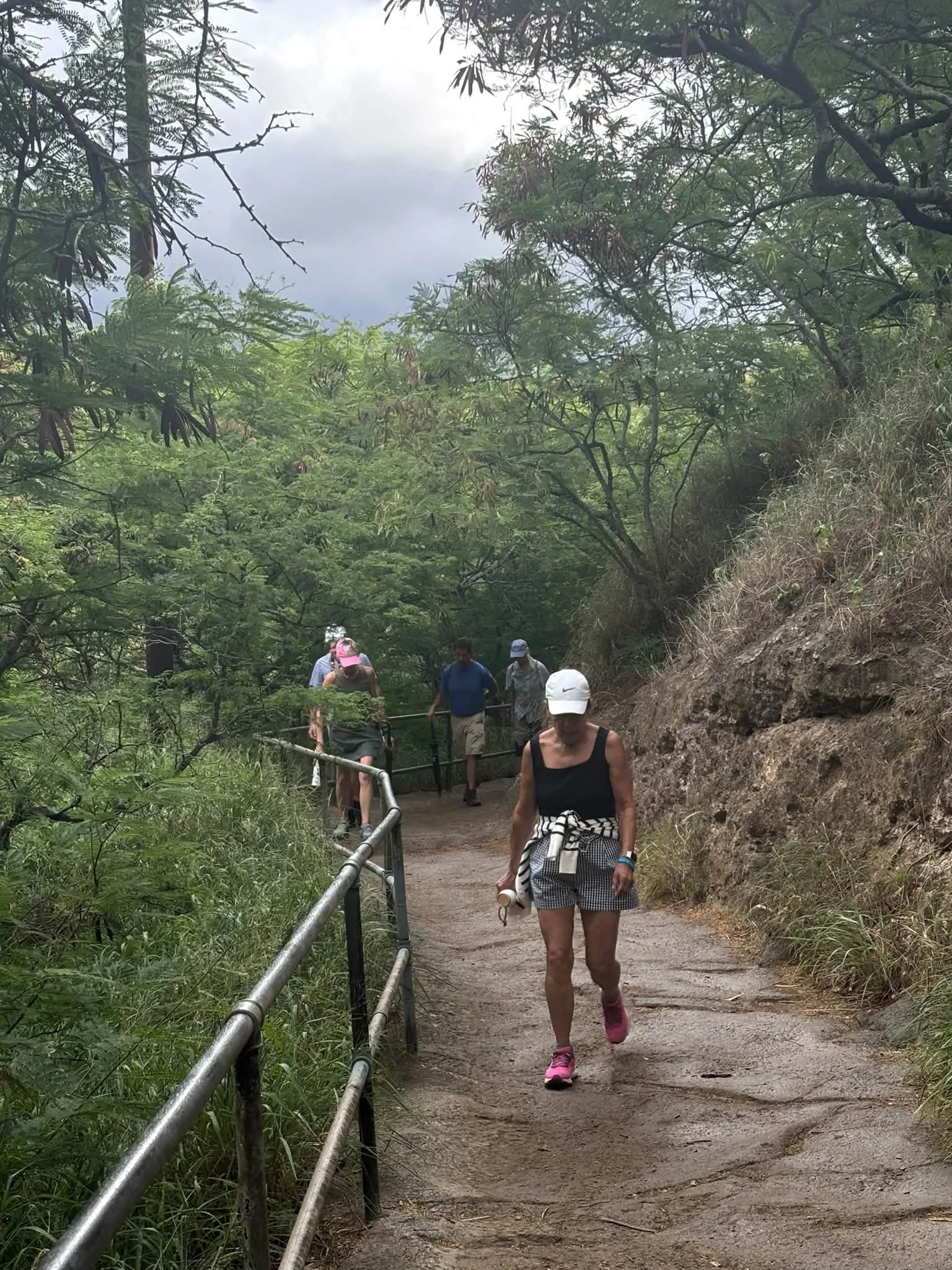 Dance Fire travelers walk along a hillside trail in Hawaii