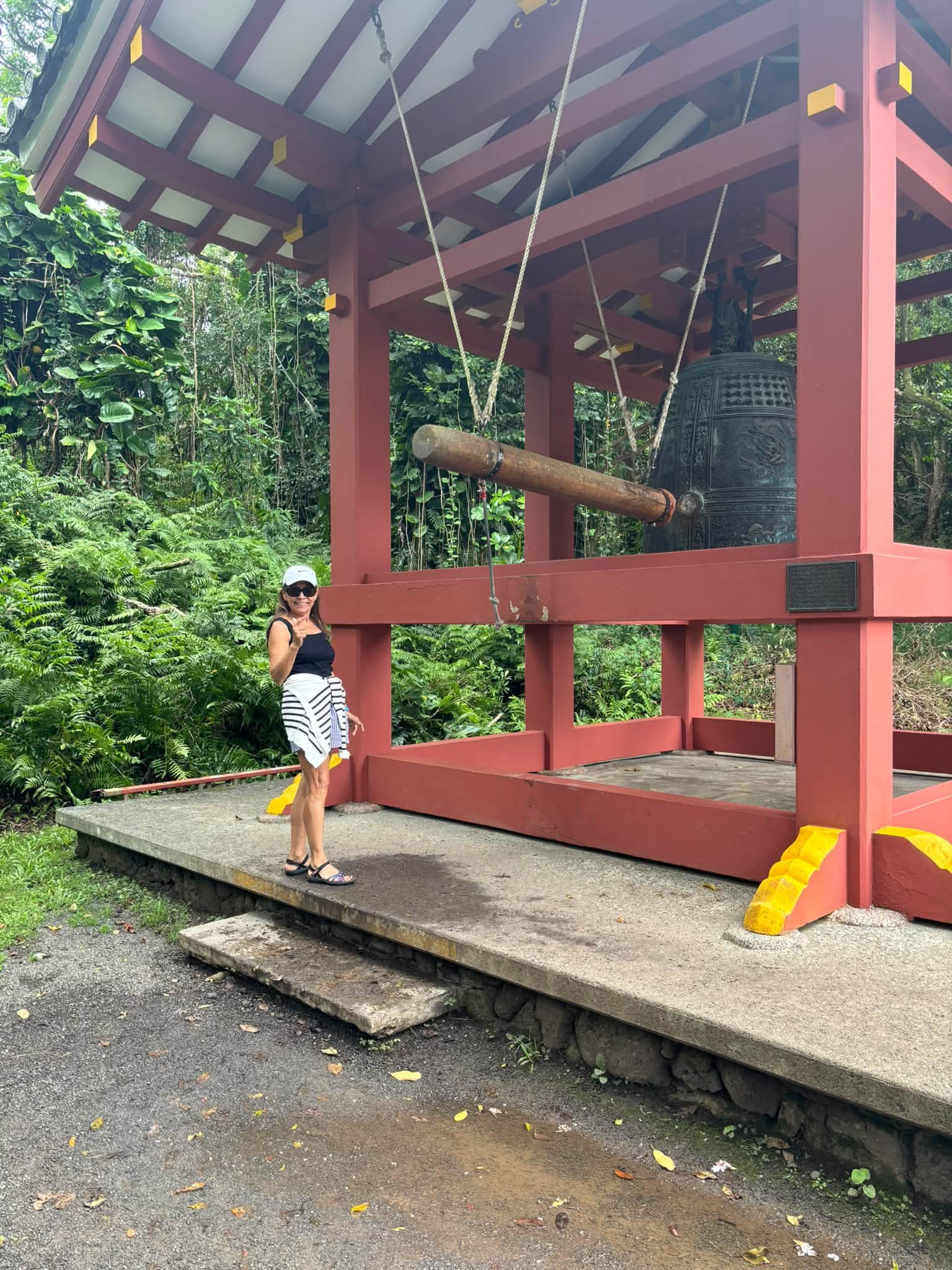 A traveler visits a red wooden pavilion surrounded by greenery