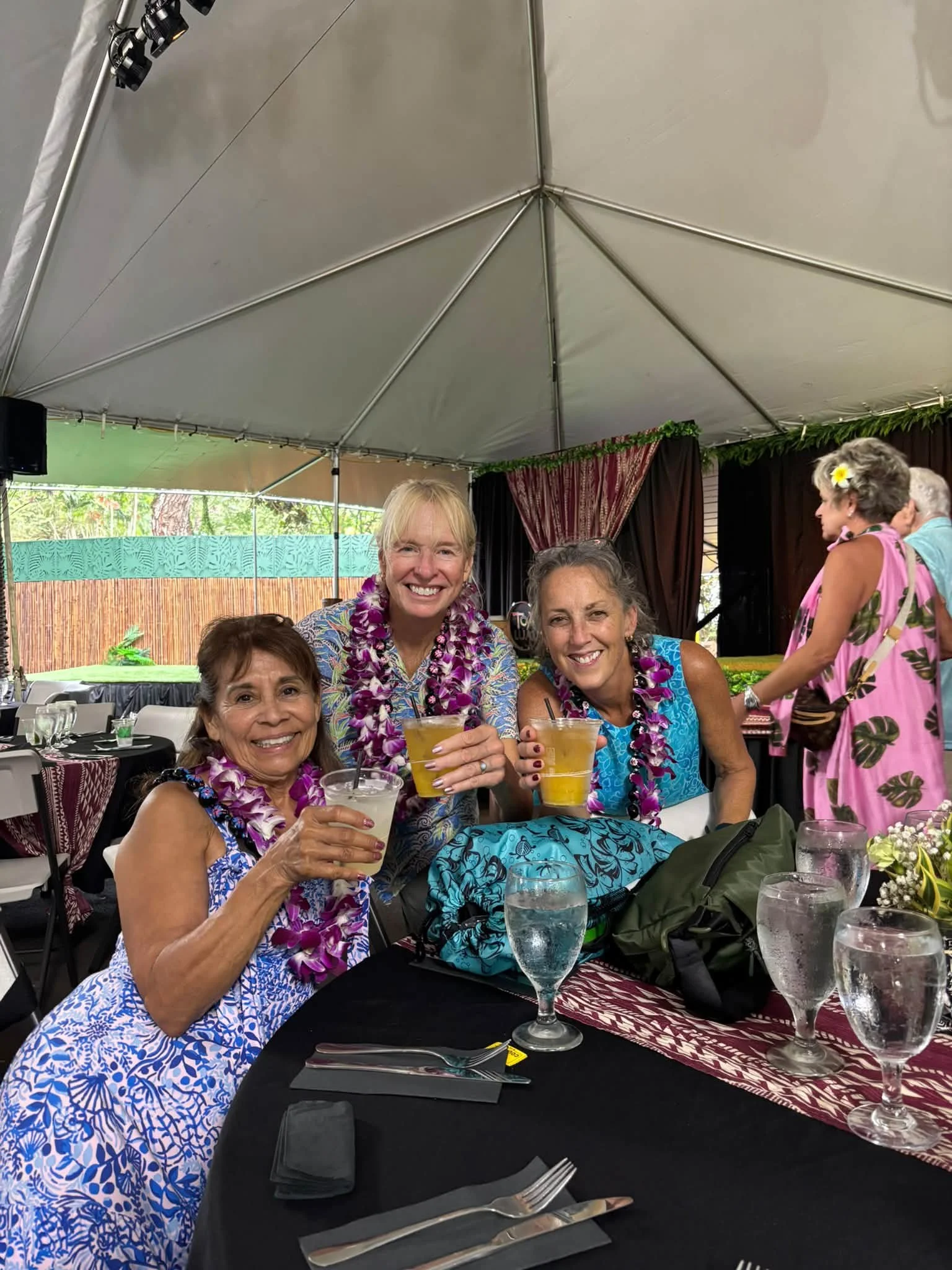 Dance Fire travelers enjoy a table gathering wearing flower leis
