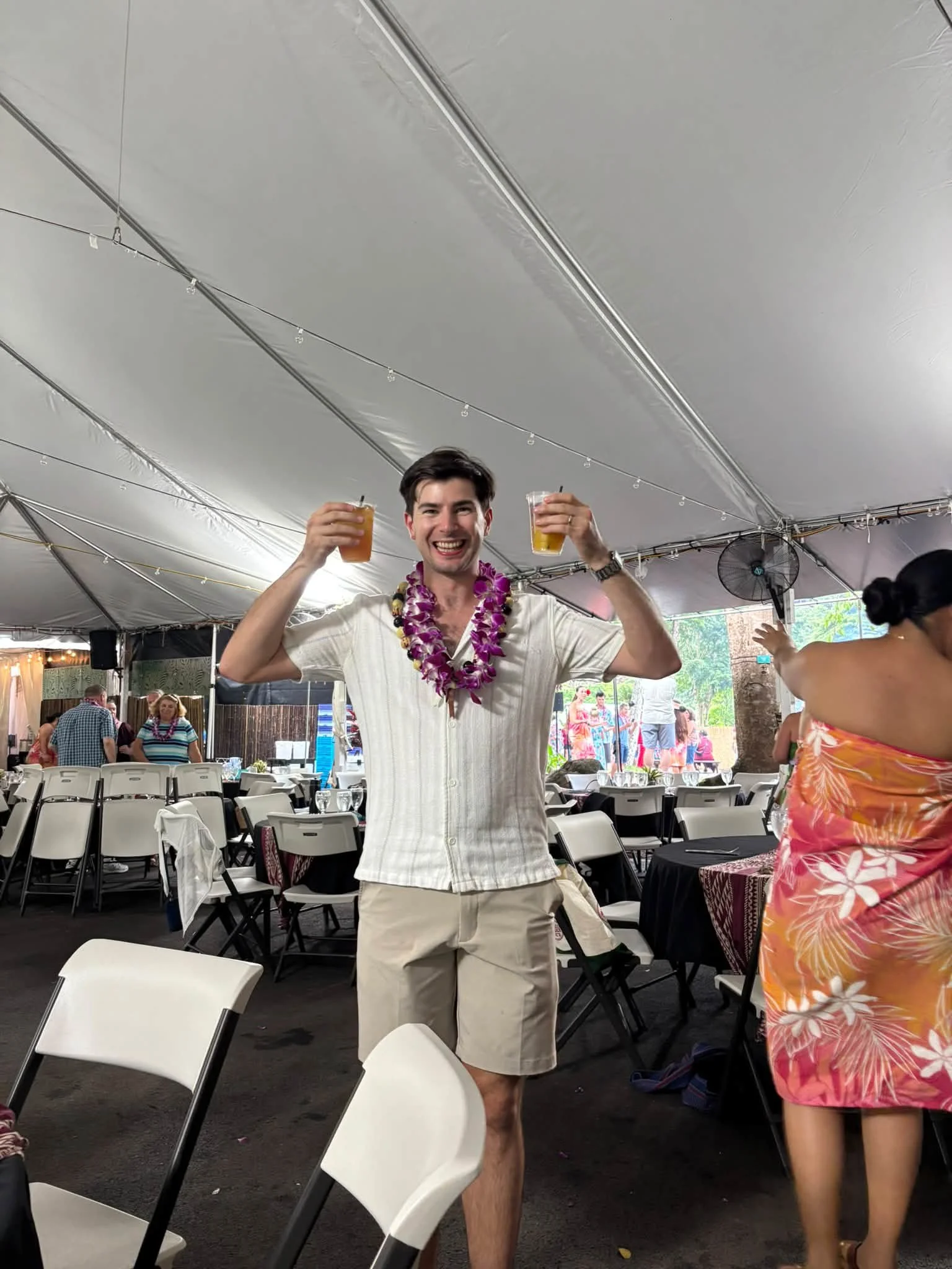 A traveler celebrates with a lei at an outdoor Hawaii gathering