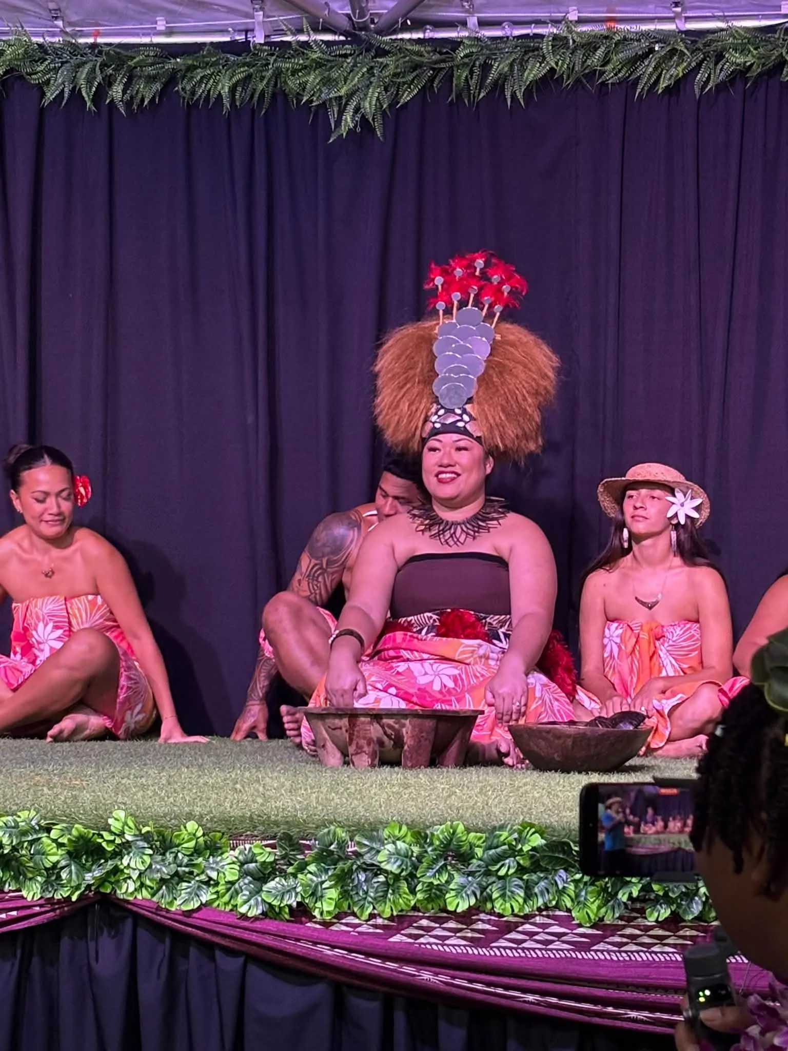 Costumed performers sit on a decorated stage during the Hawaii outing