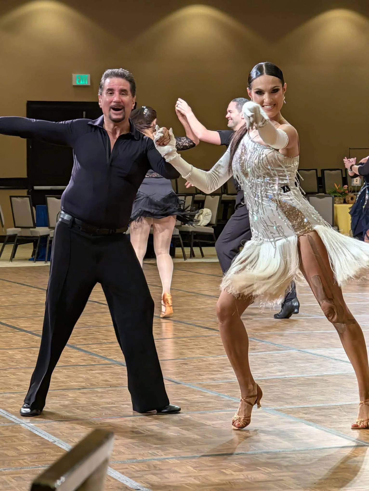 A competition pair in silver and black performs at Hawaii Star Ball