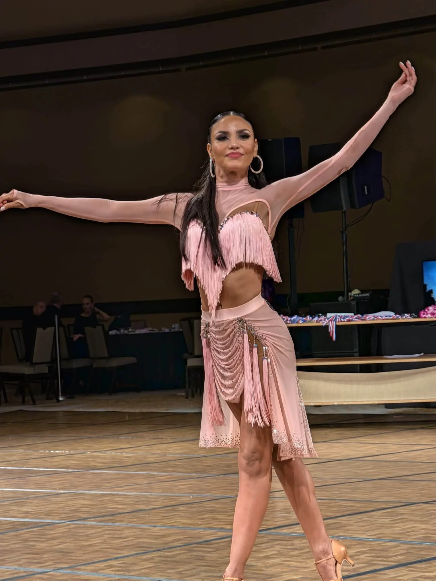 A dancer in pink extends her arms during a Hawaii Star Ball routine