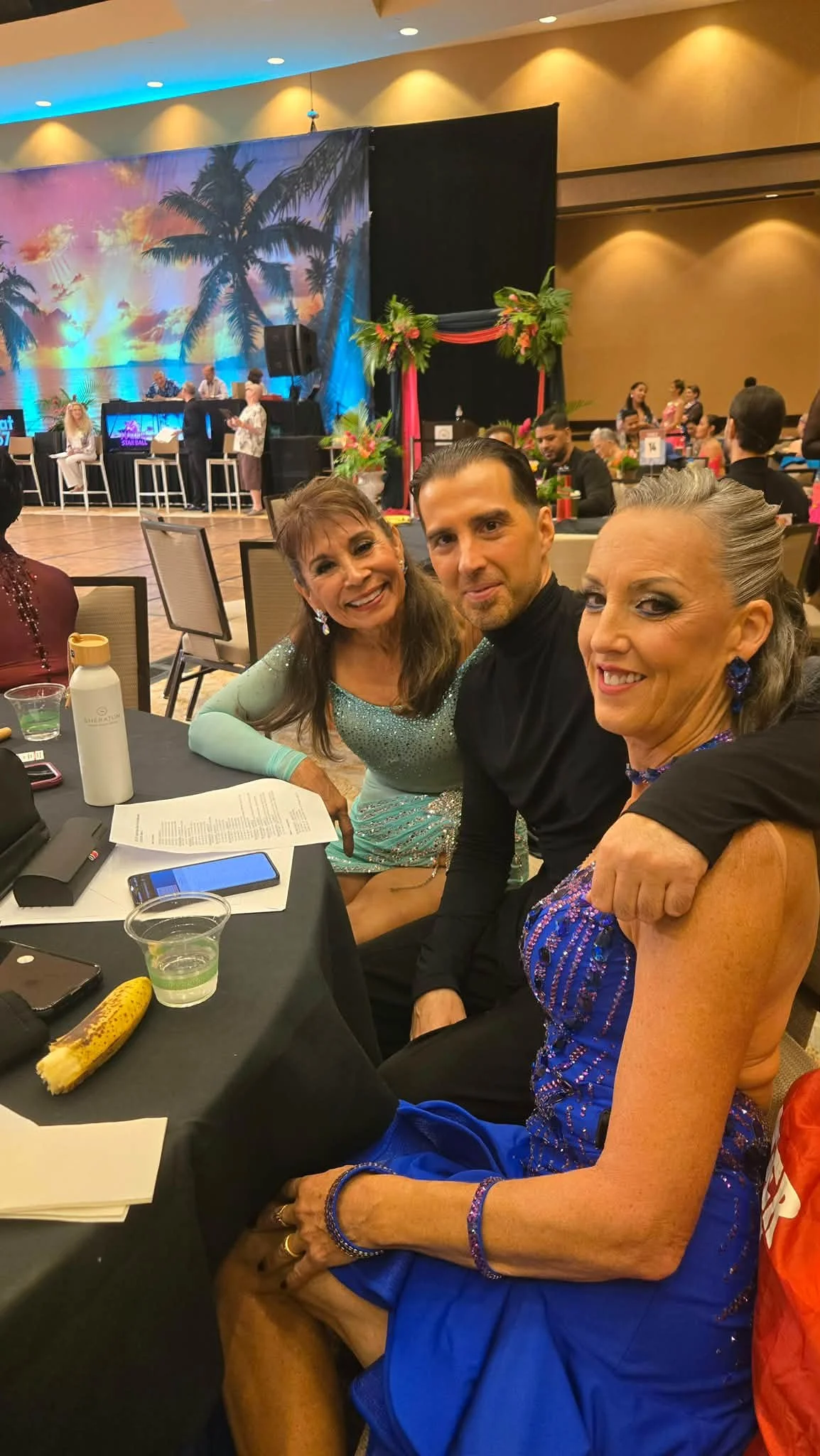 Dance Fire team members sit together beside the Hawaii competition floor